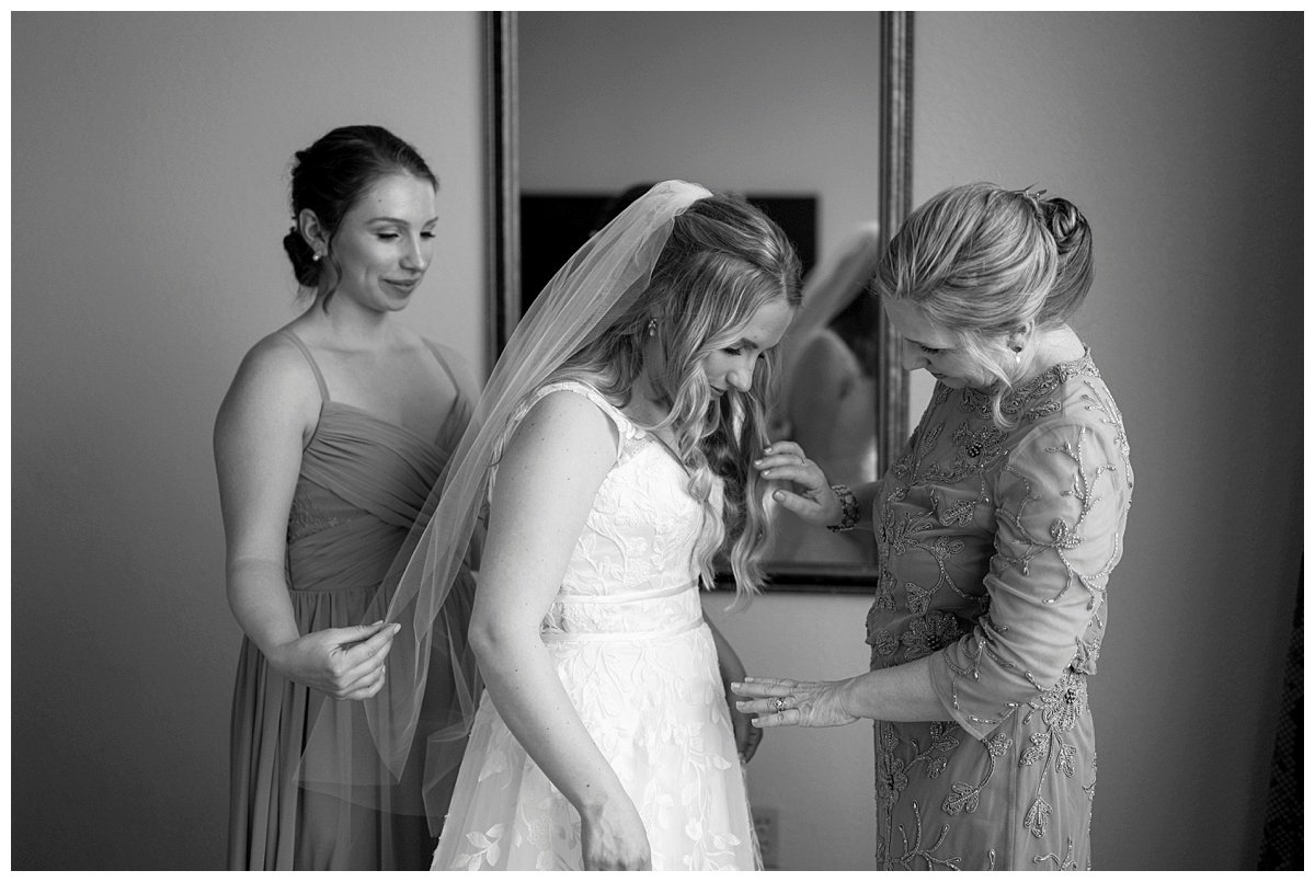 black and white image of bride's veil being put on