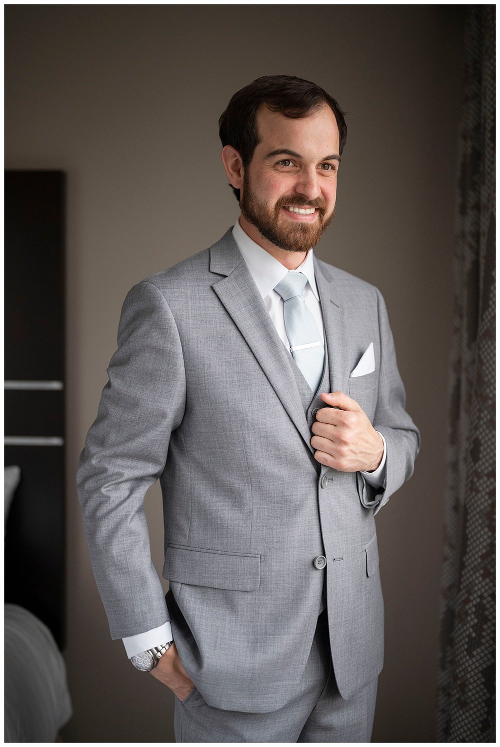 groom in gray suit standing and smiling at New England wedding photographer