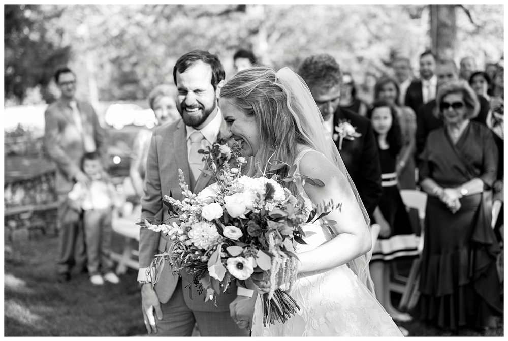 black and white image of bride and groom laughing during New England wedding ceremony