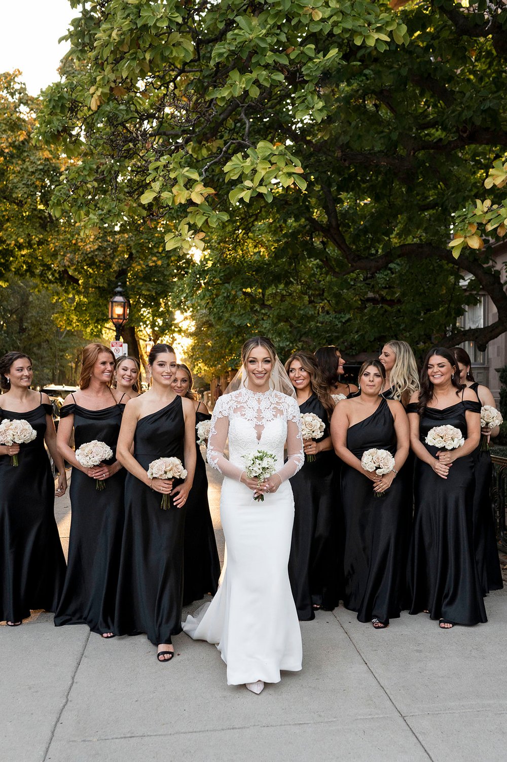all black bridesmaids dresses during bridal party photos with white floral