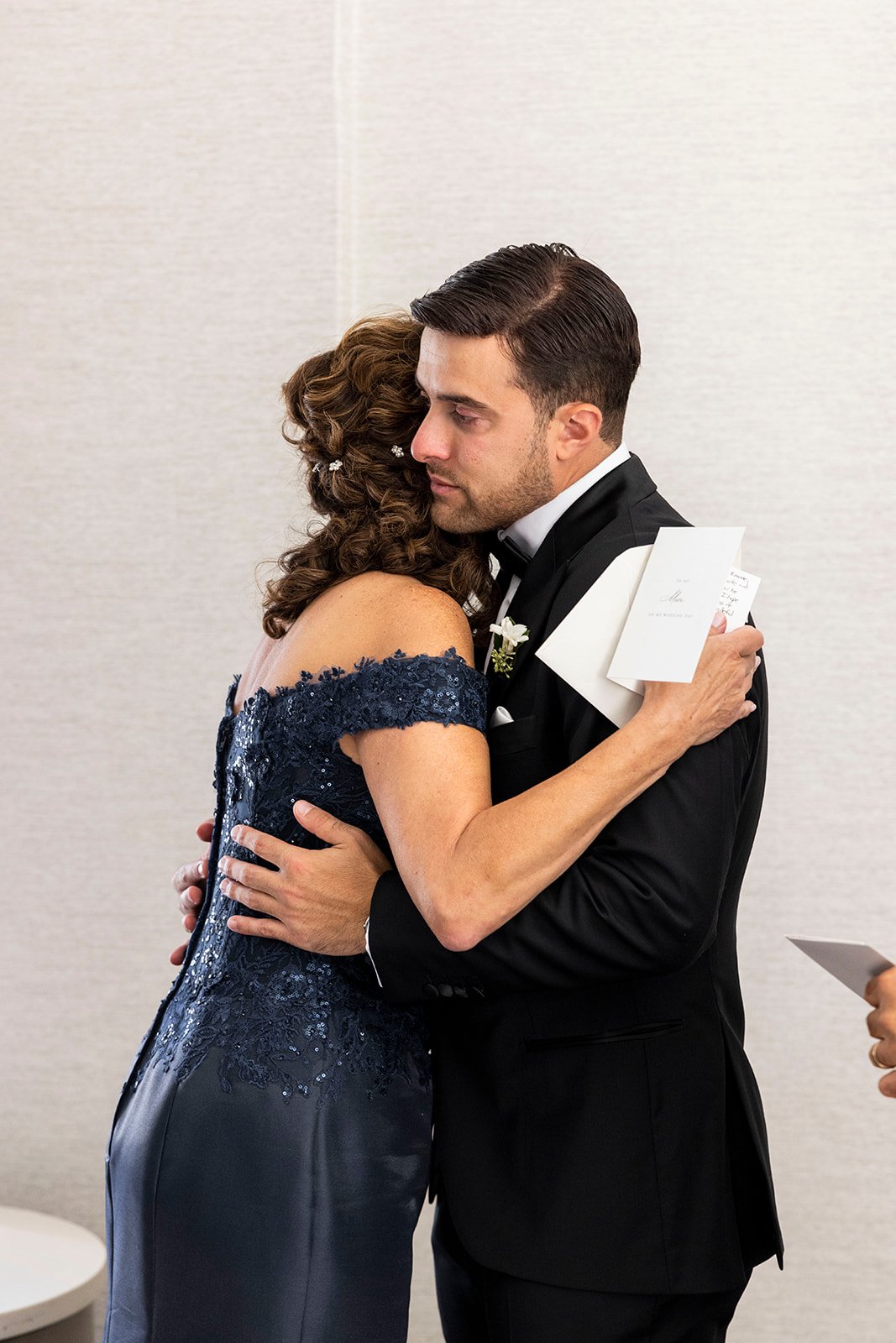 groom hugging parents during wedding day