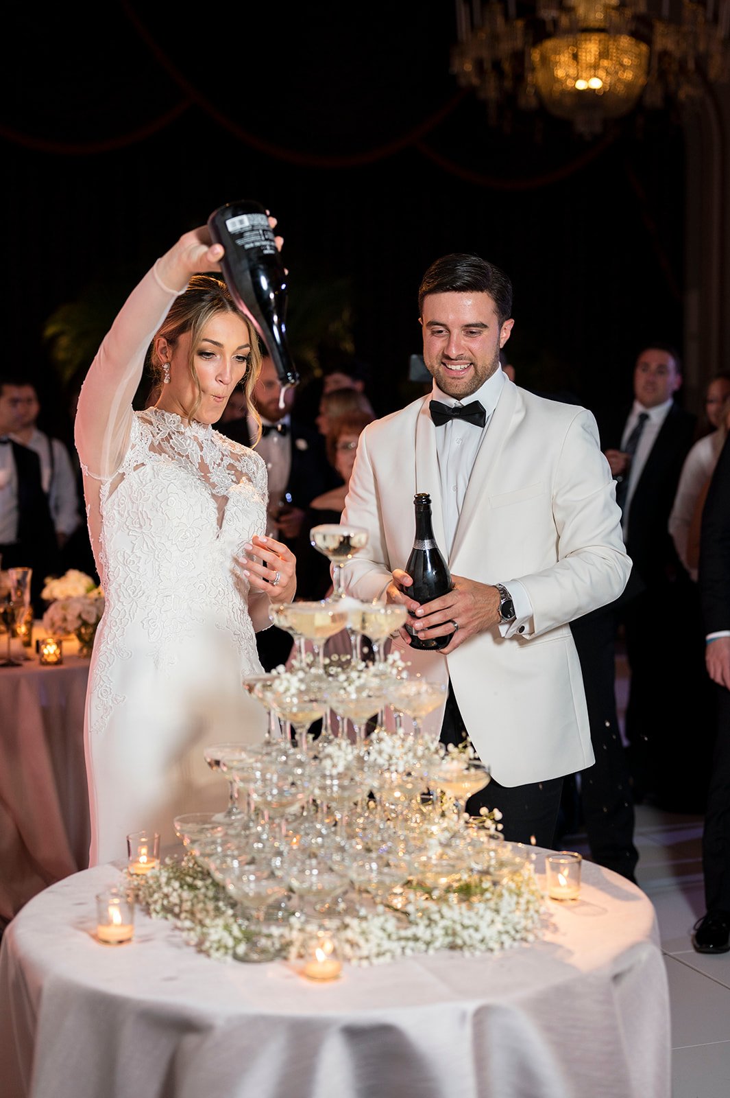 bride and groom pouring champagne in tower