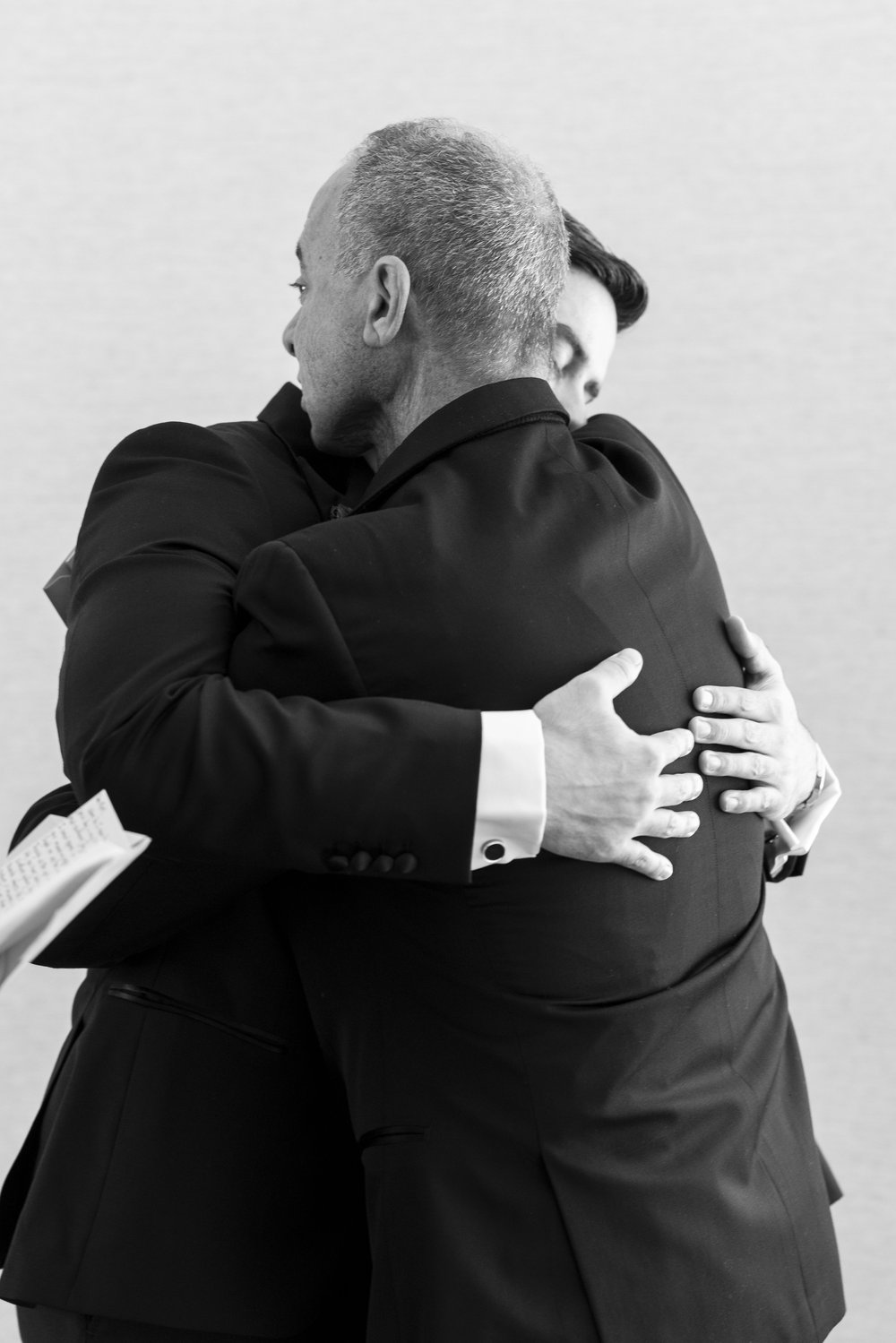 groom hugging parents during wedding day