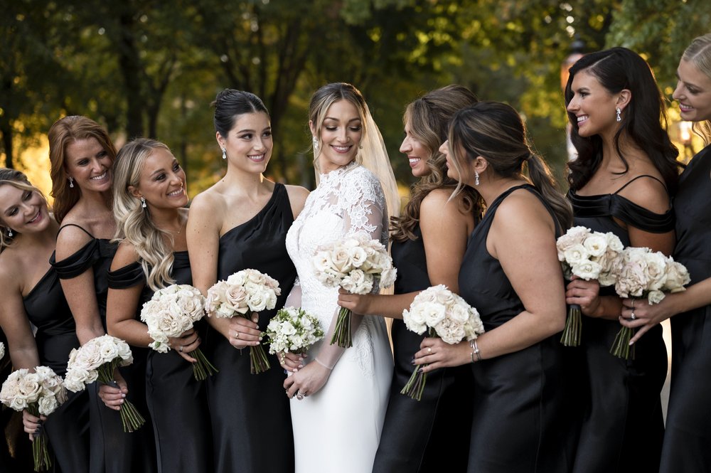 all black bridesmaids dresses during bridal party photos with white floral