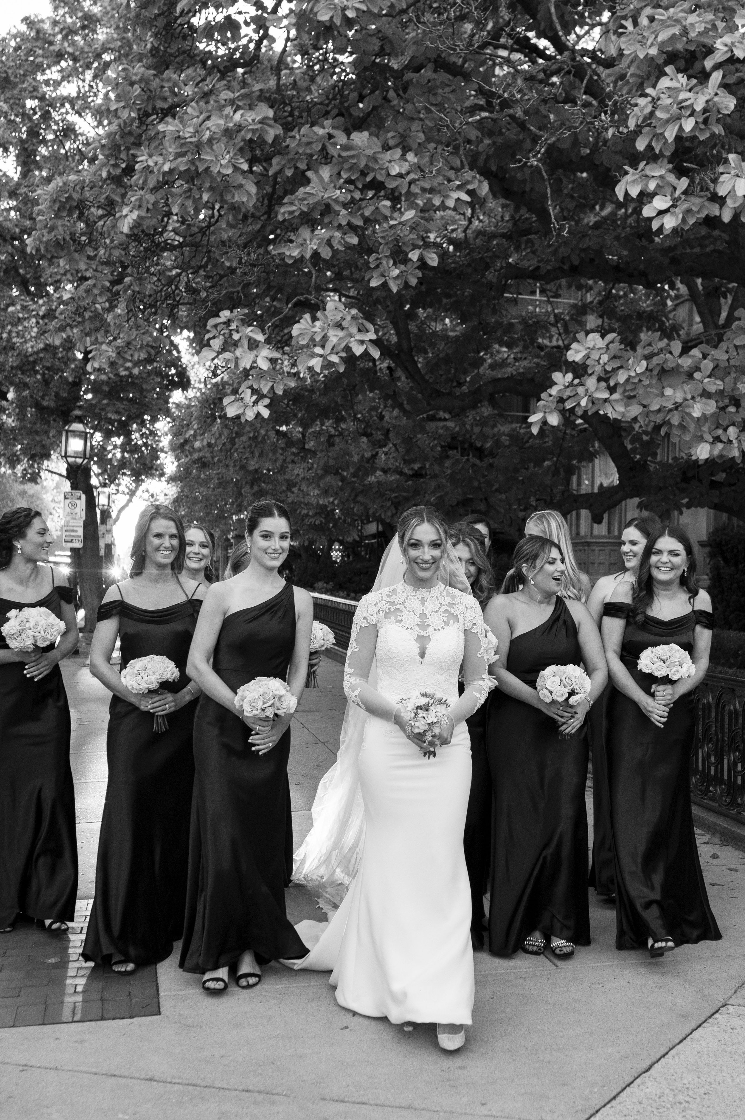 all black bridesmaids dresses during bridal party photos with white floral