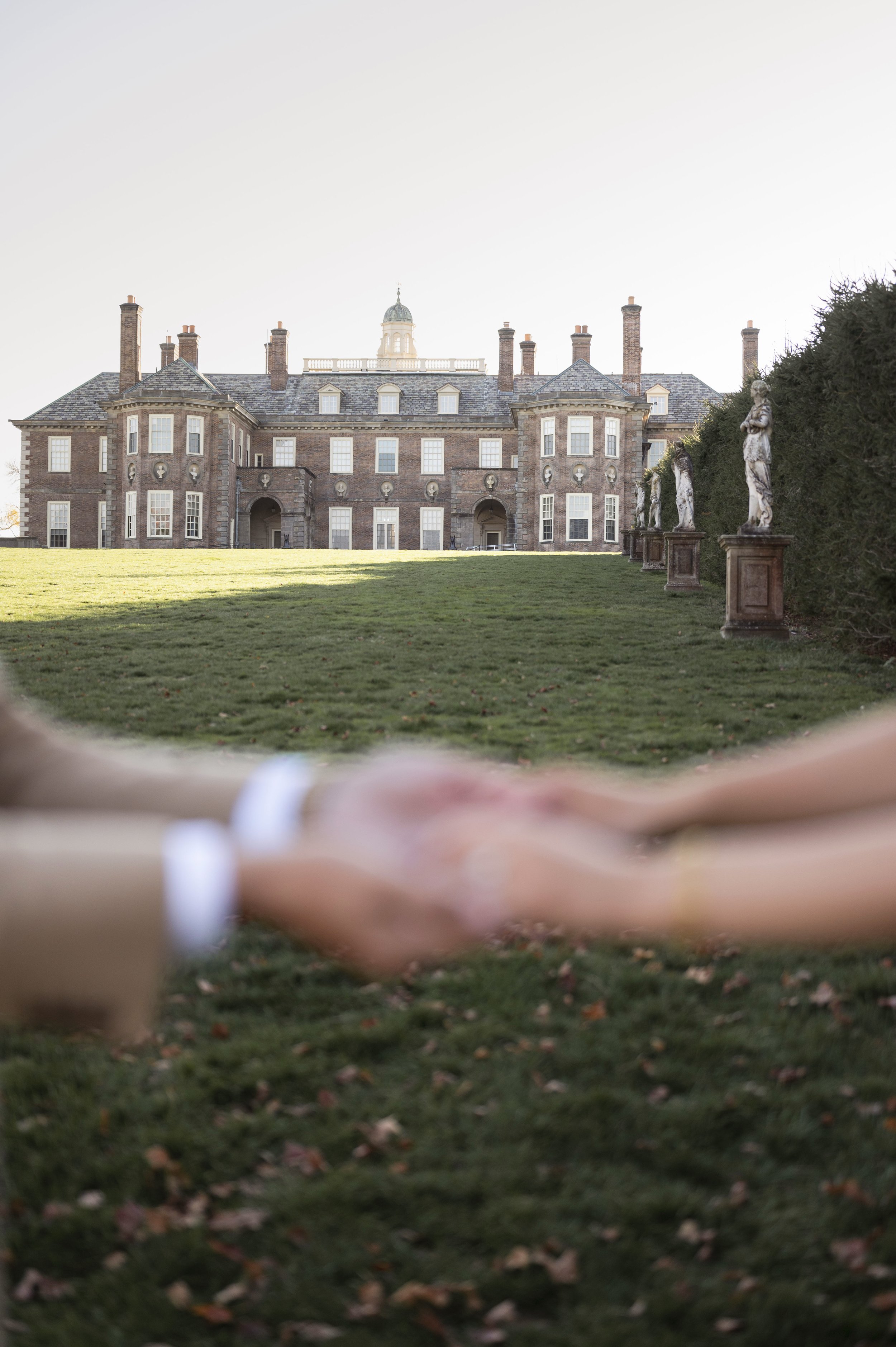 couple holding hands during engagement shoot at crane estate