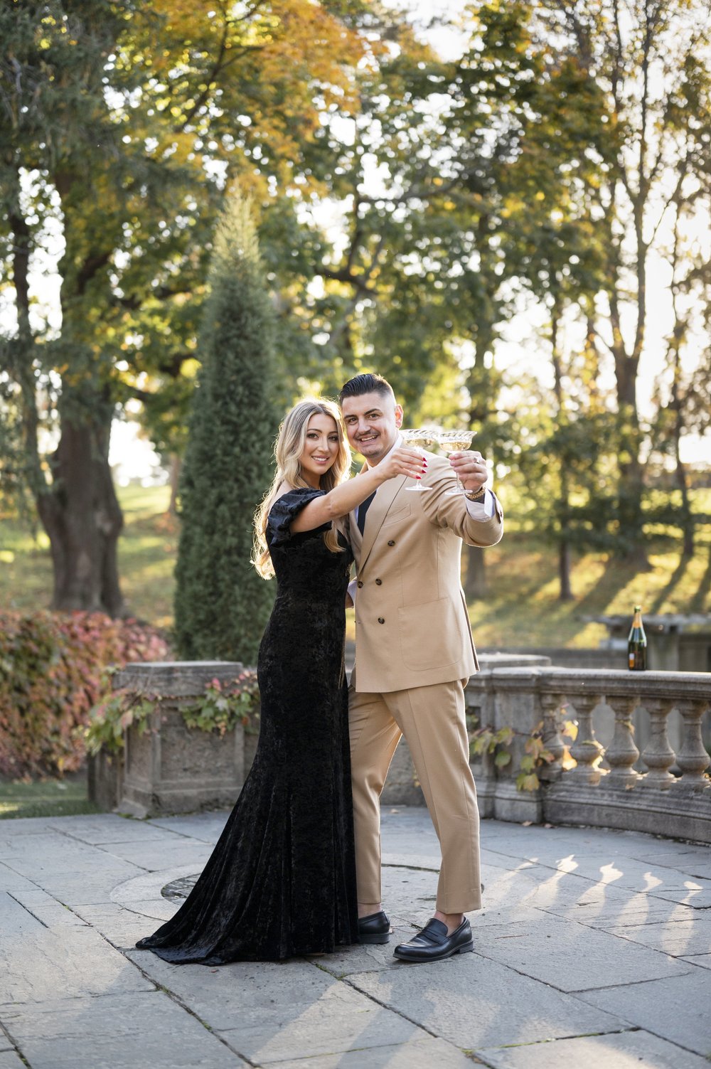 couple cheering champagne during engagement photos