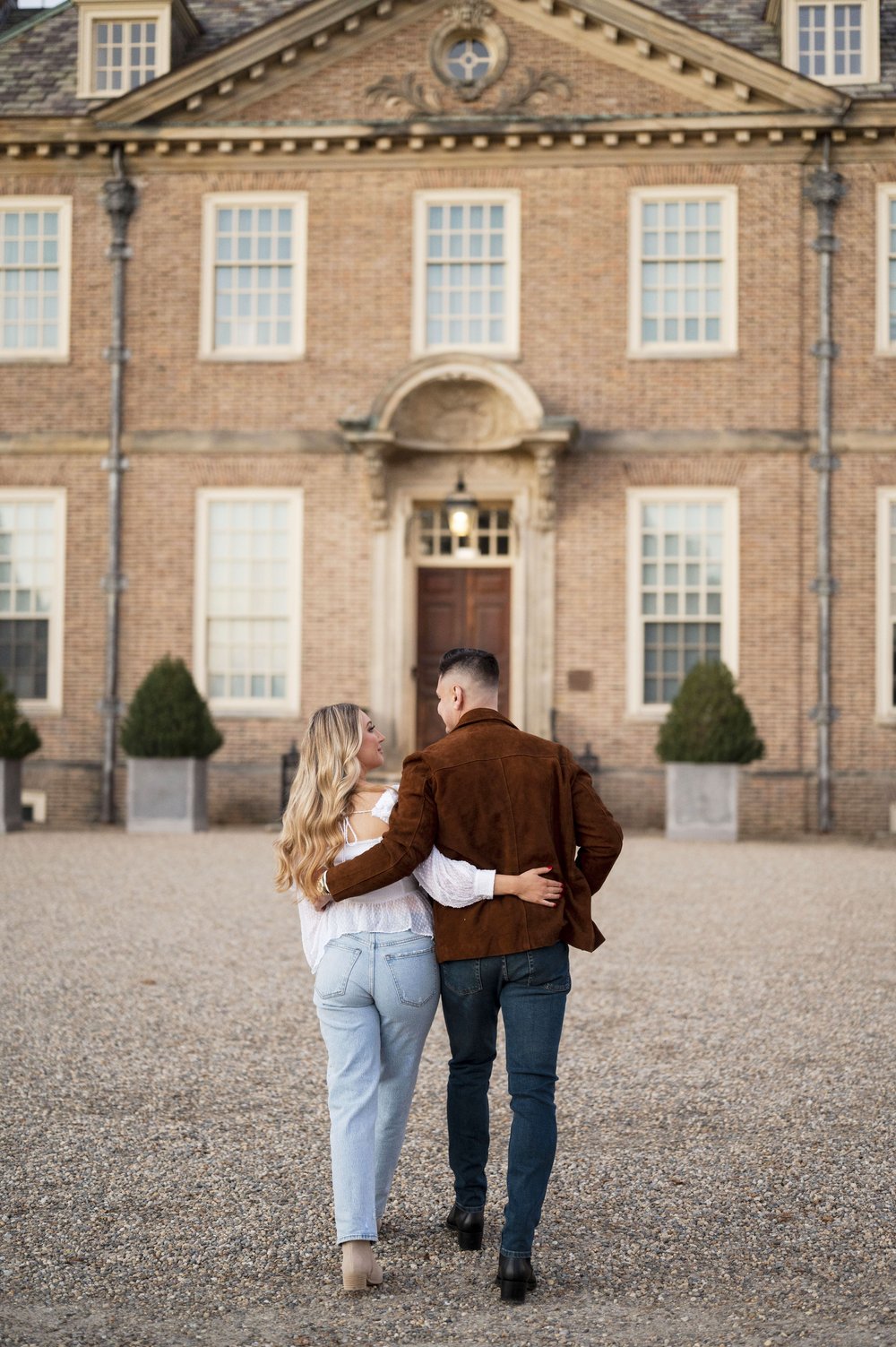 couple walking at castle hill on the crane estate holding each other