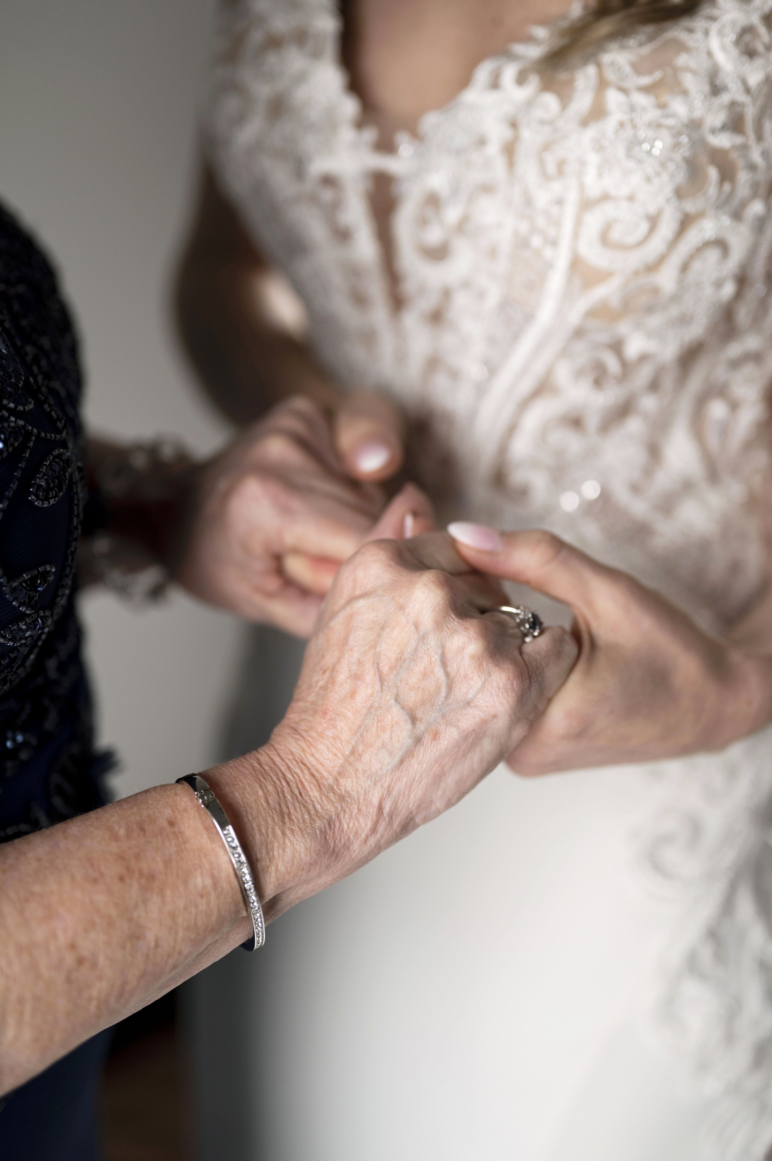 close up hands of bride and mother
