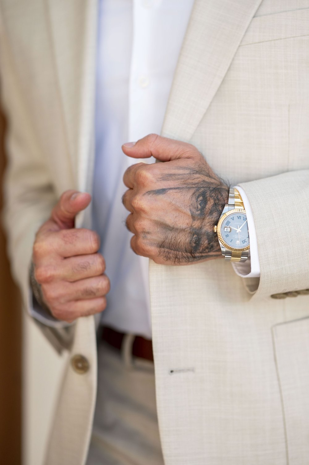 close up of a guy hangs holding a suit jacket