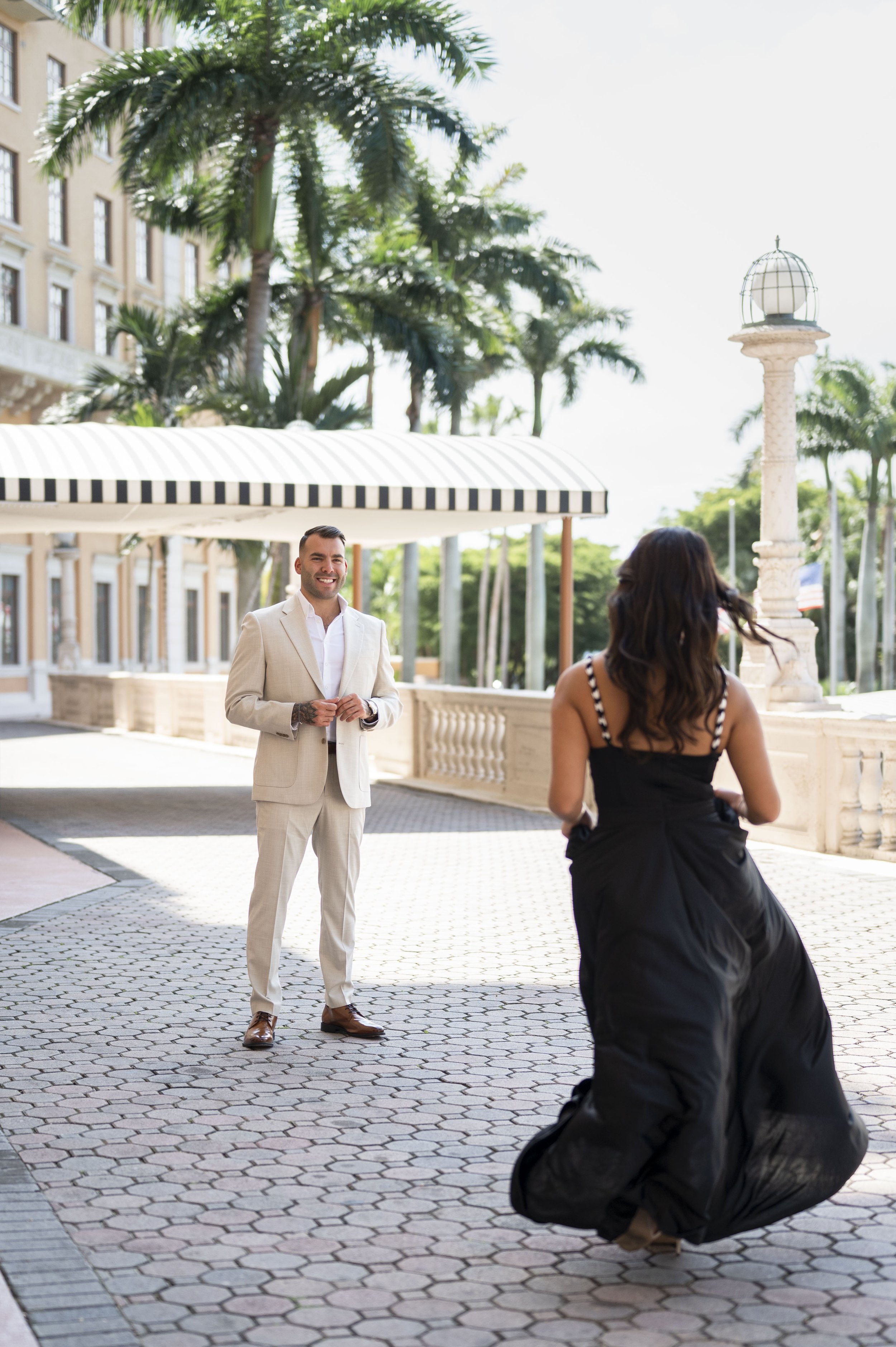 girl wearing a black dress running towards a guy wearing a suit