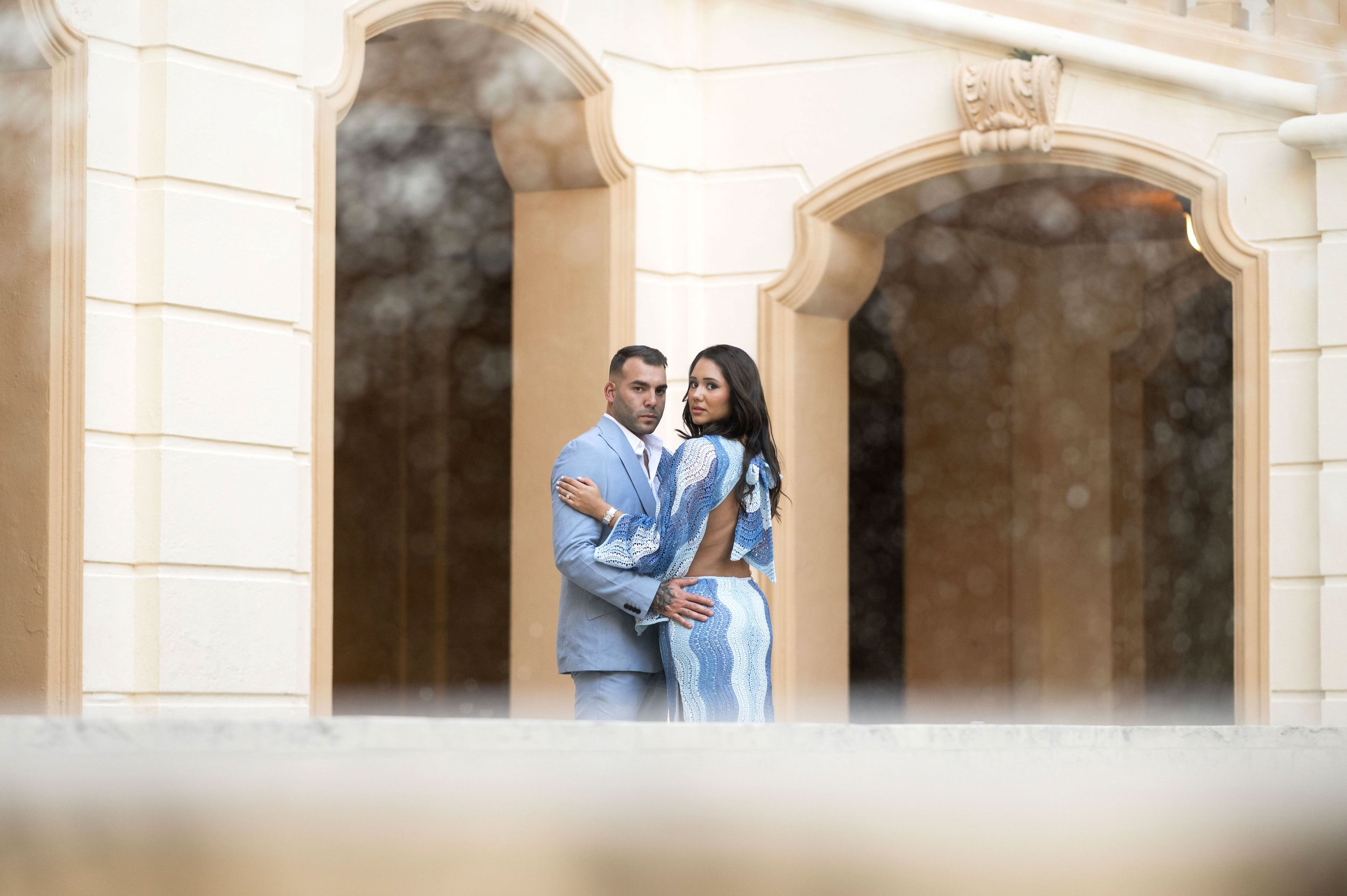 girl and guy posing behind a fountain