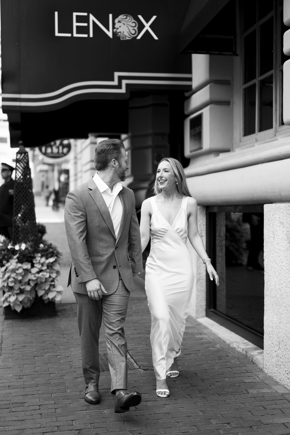 briede and groom walking in front of the lenox hotel boston