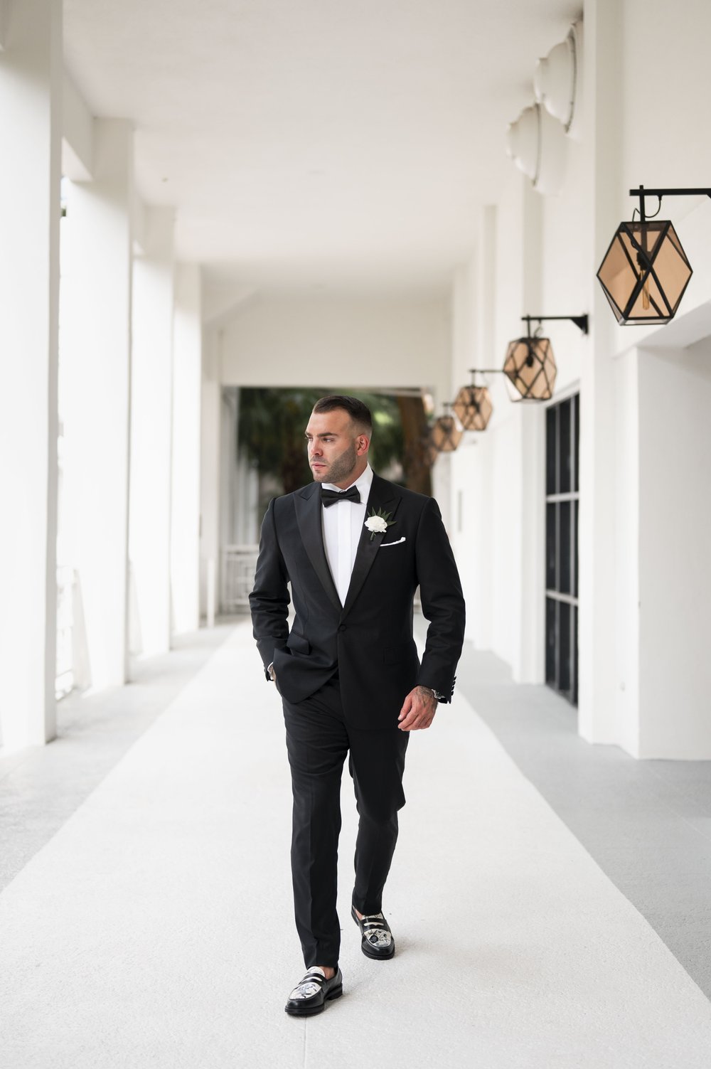 groom wearing a tuxedo walking towards the camera