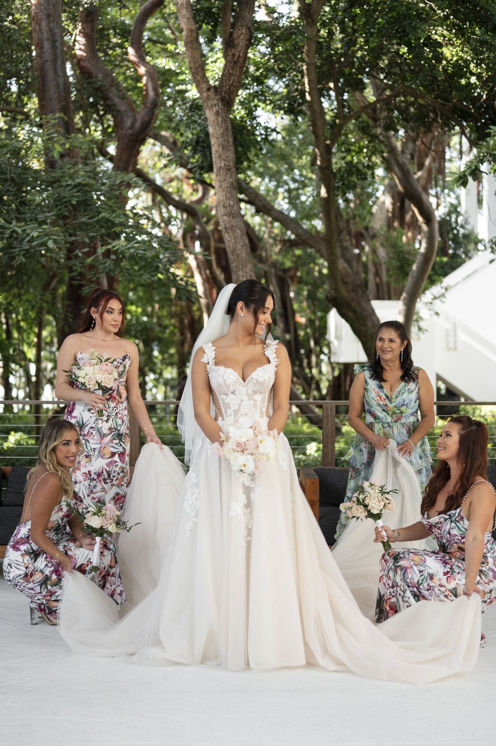 bride and bridesmaids arranging bride's dress