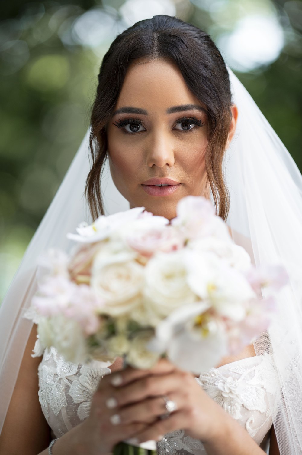 bride holding her bouquet close to her face