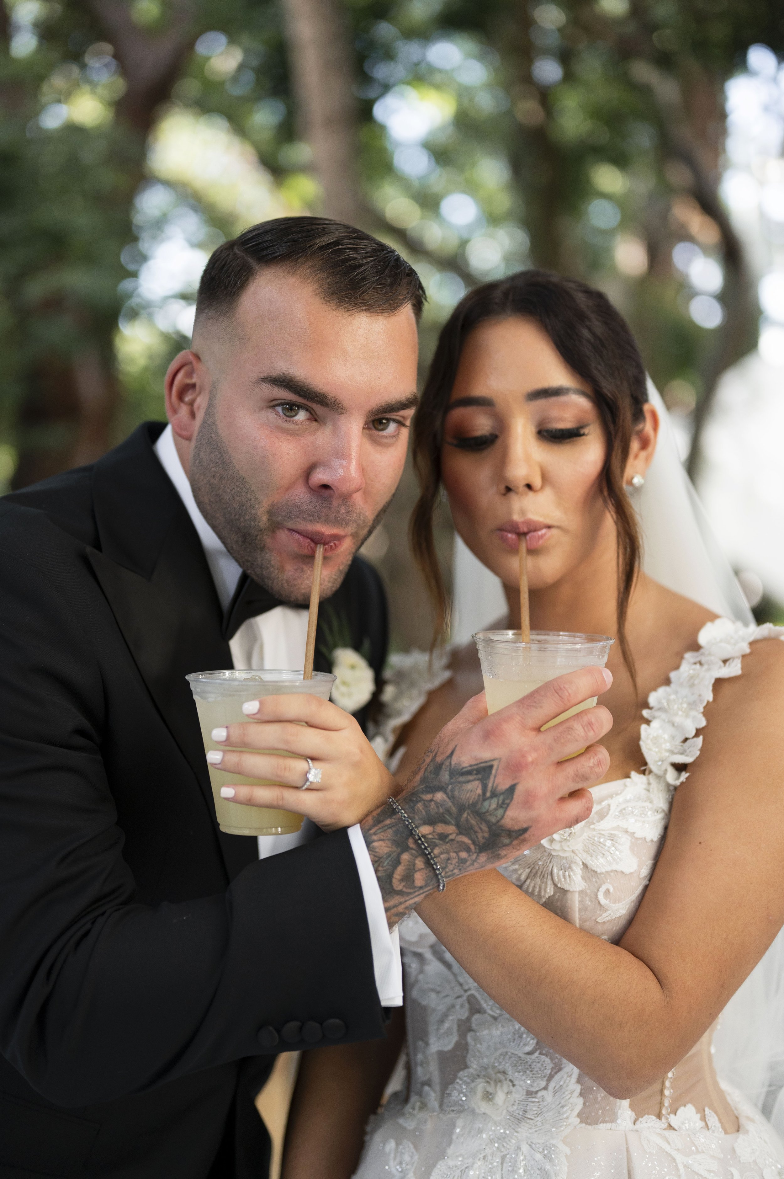 bride and groom sipping on a cocktail together