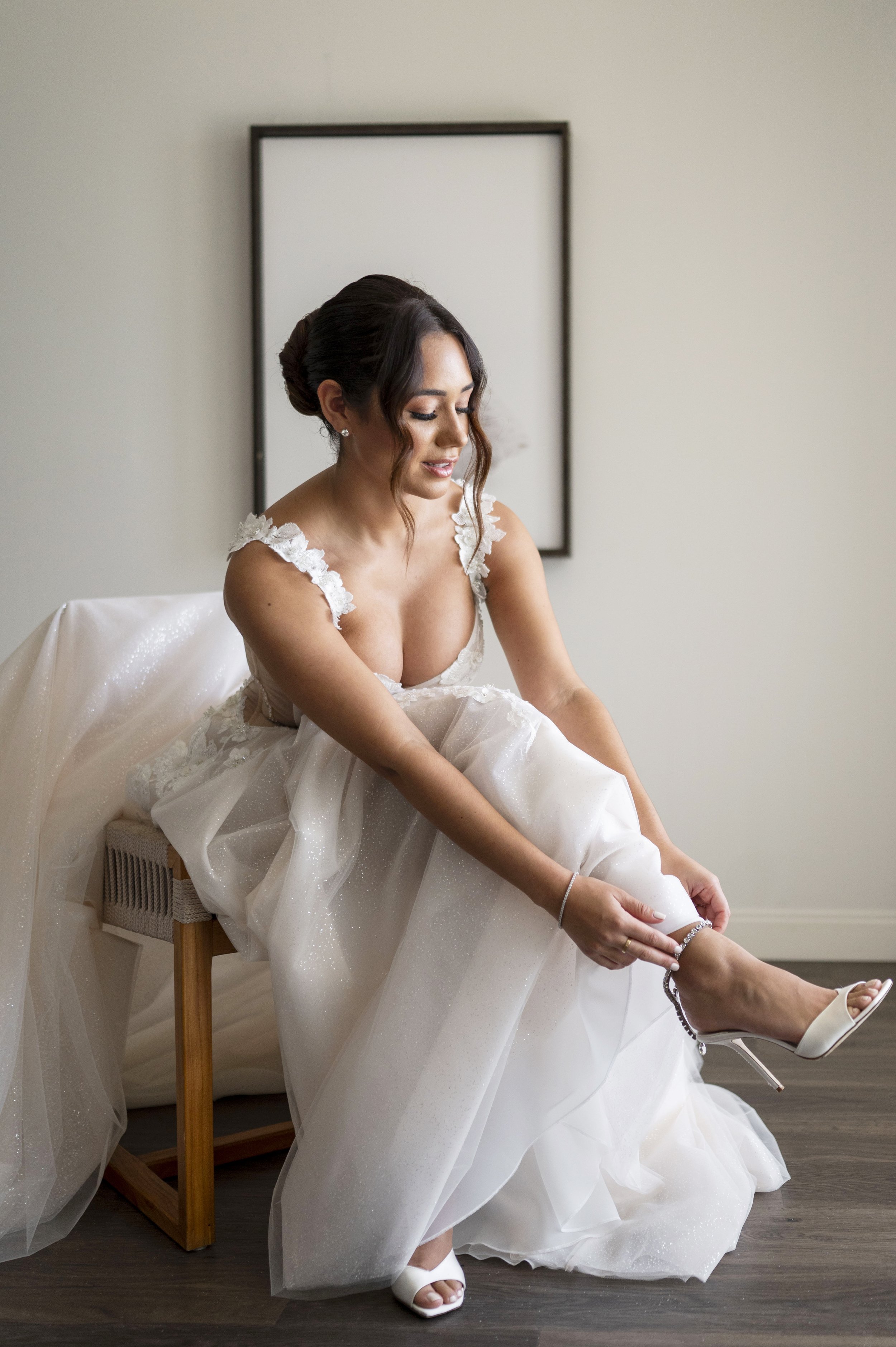 bride putting on her wedding shoes