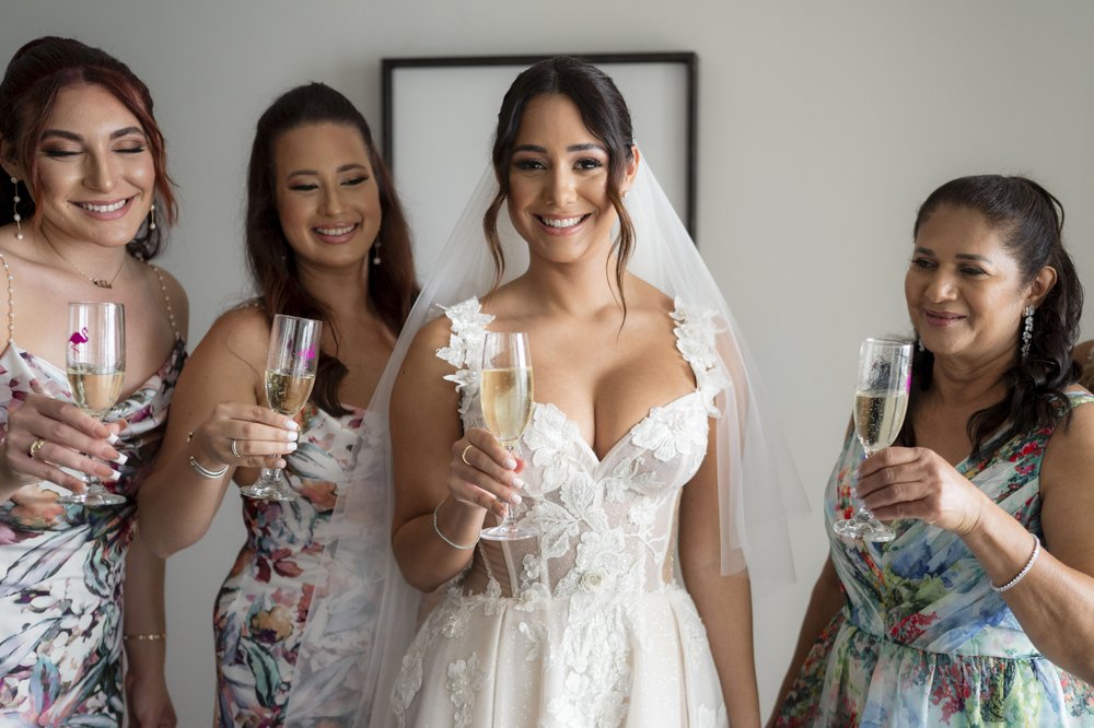bride cheering with her bridesmaids with champagne 