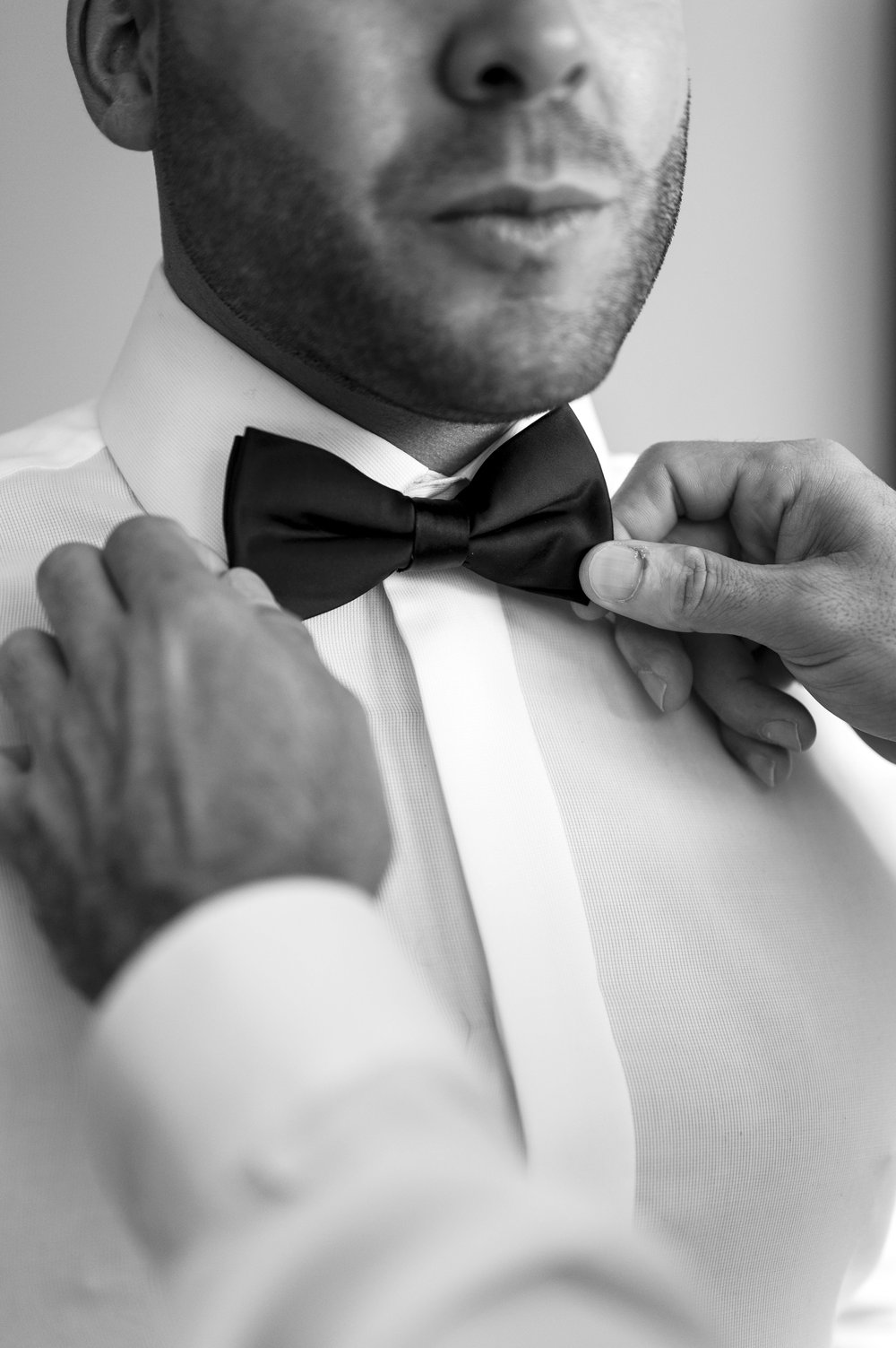 close up of hands fixing bow tie