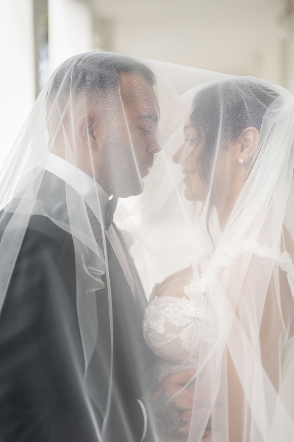 bride and groom under a veil