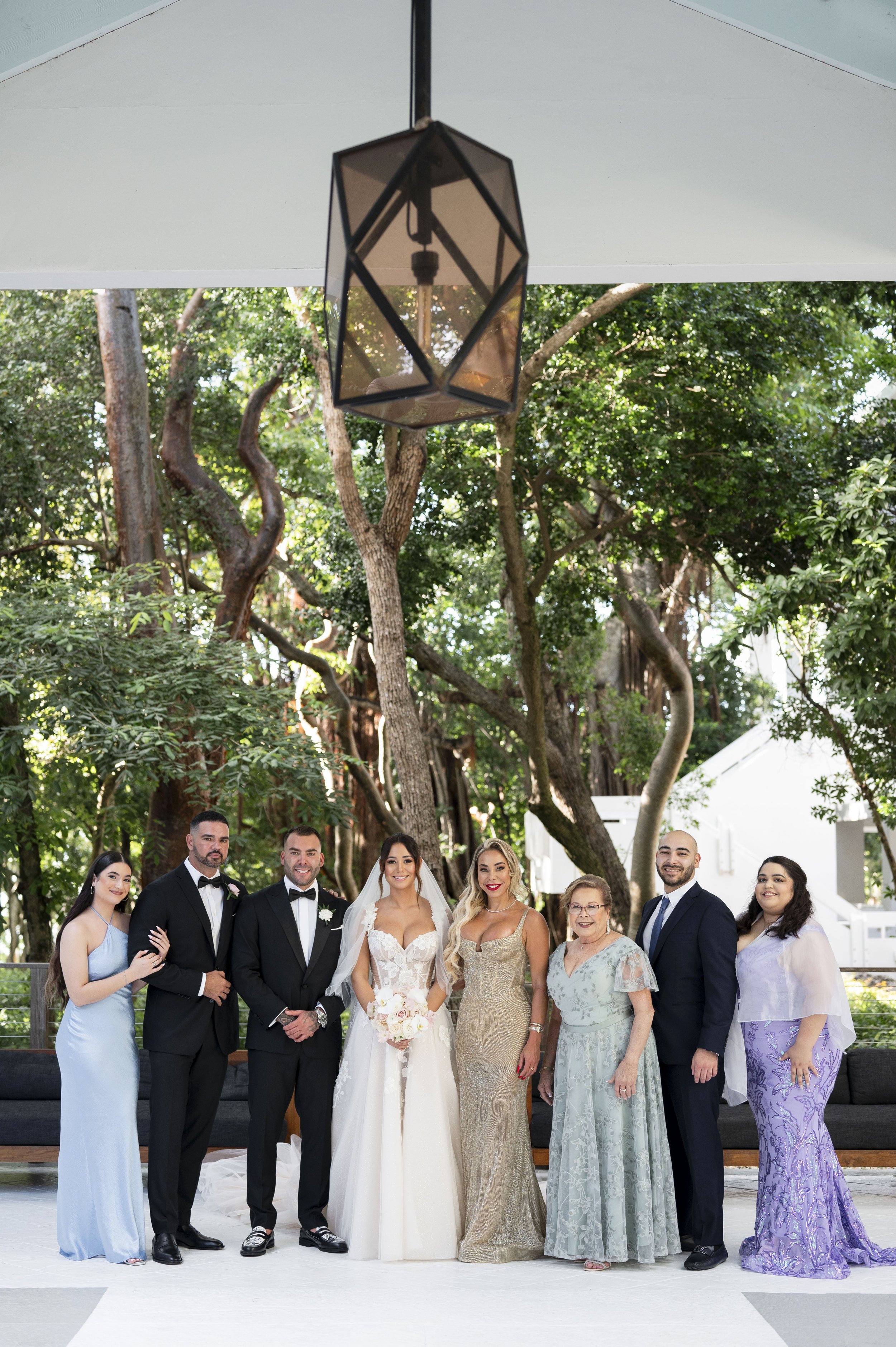 bride and groom posing with family