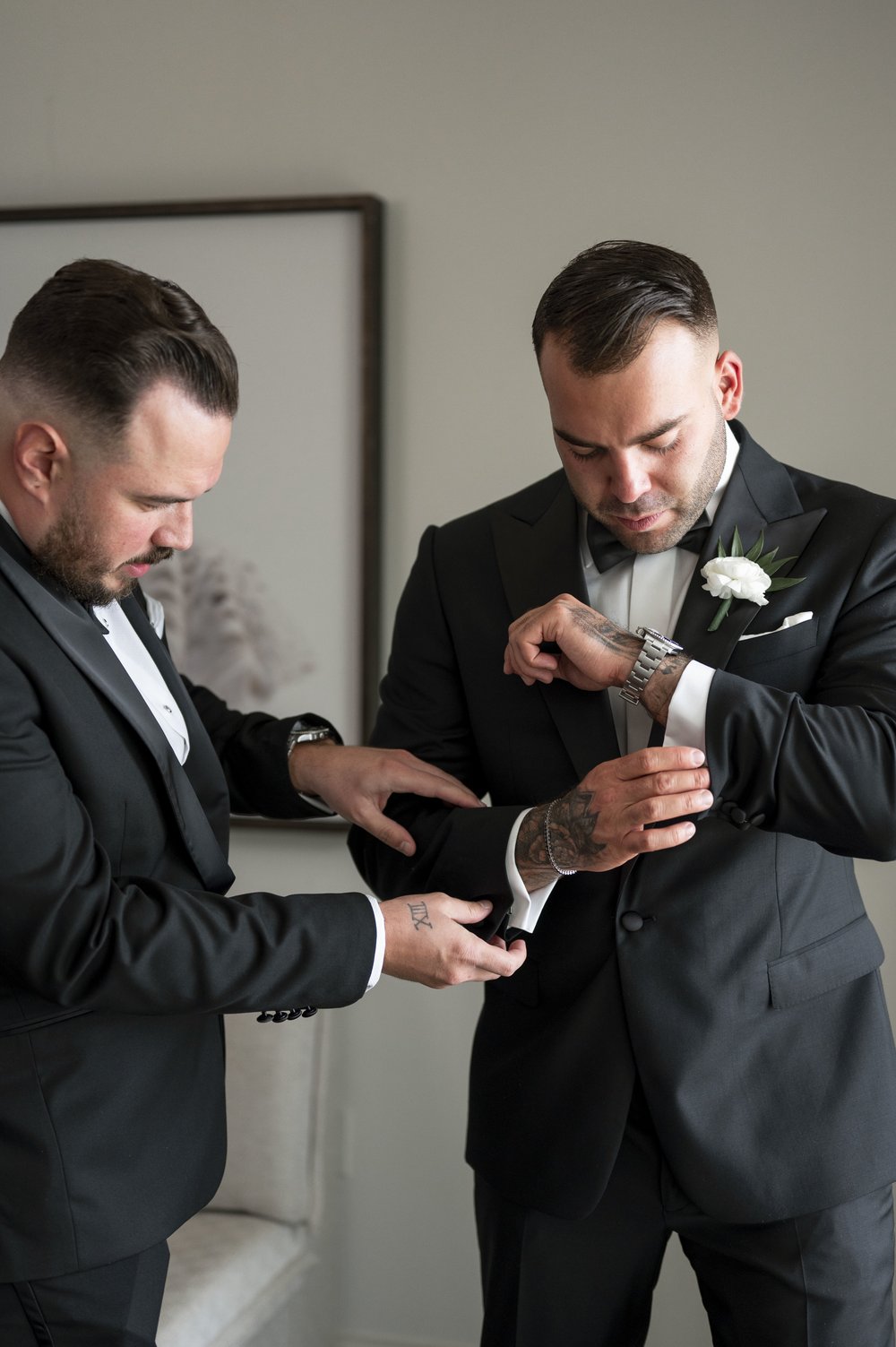 groomsmen helps groom to put his cuffs