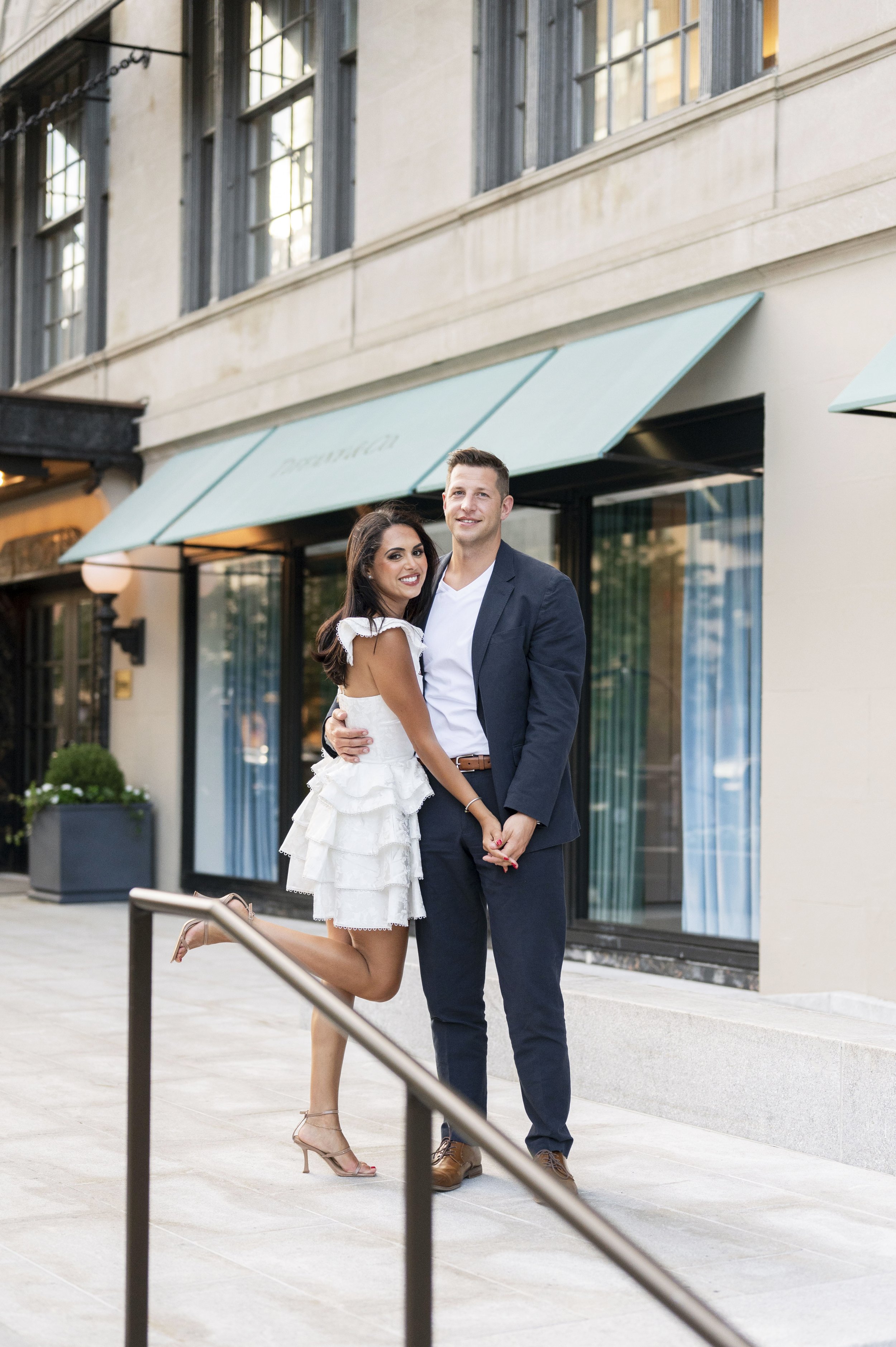 bride and groom holding hands in front of the Tiffany store in Boaton