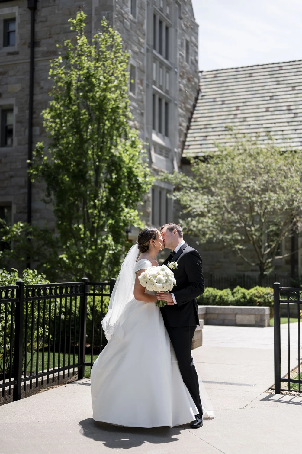 bride and groom kissing with boston collage in the back ground