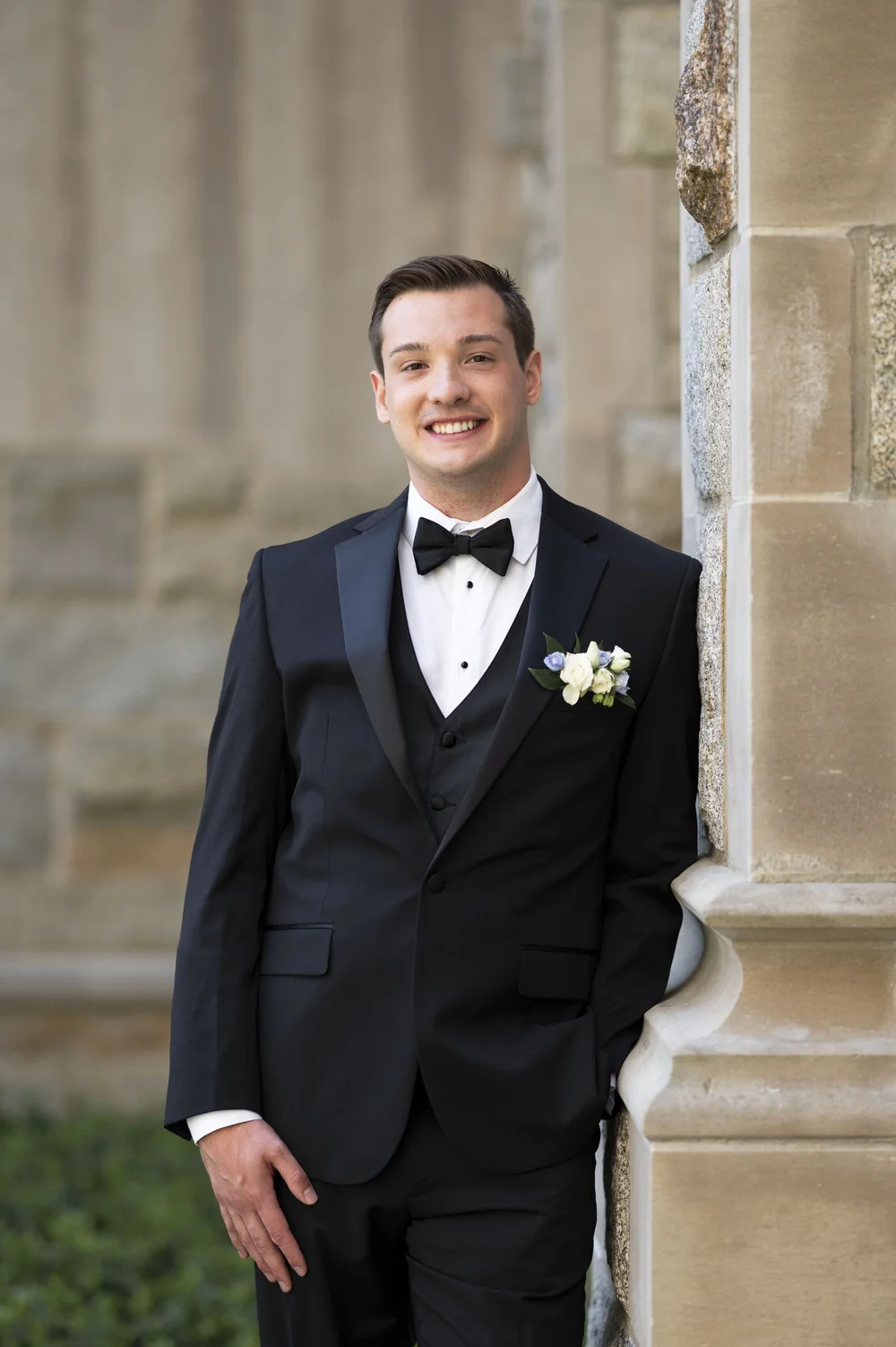 groom leaning on a wall