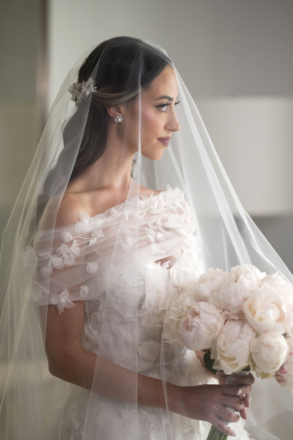 bride wearing bridal dress and veil holding bouquet
