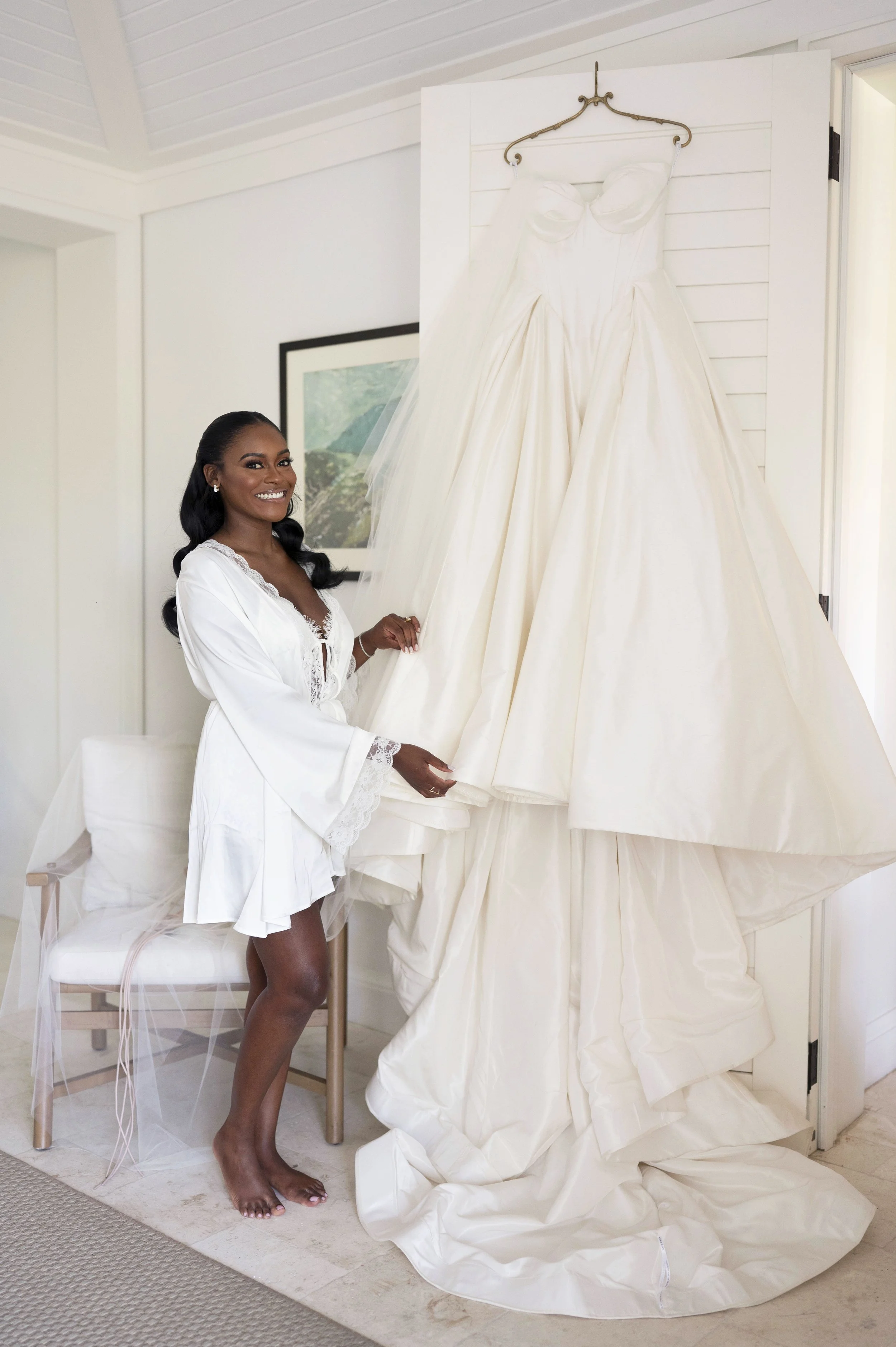bride posing next to her gown