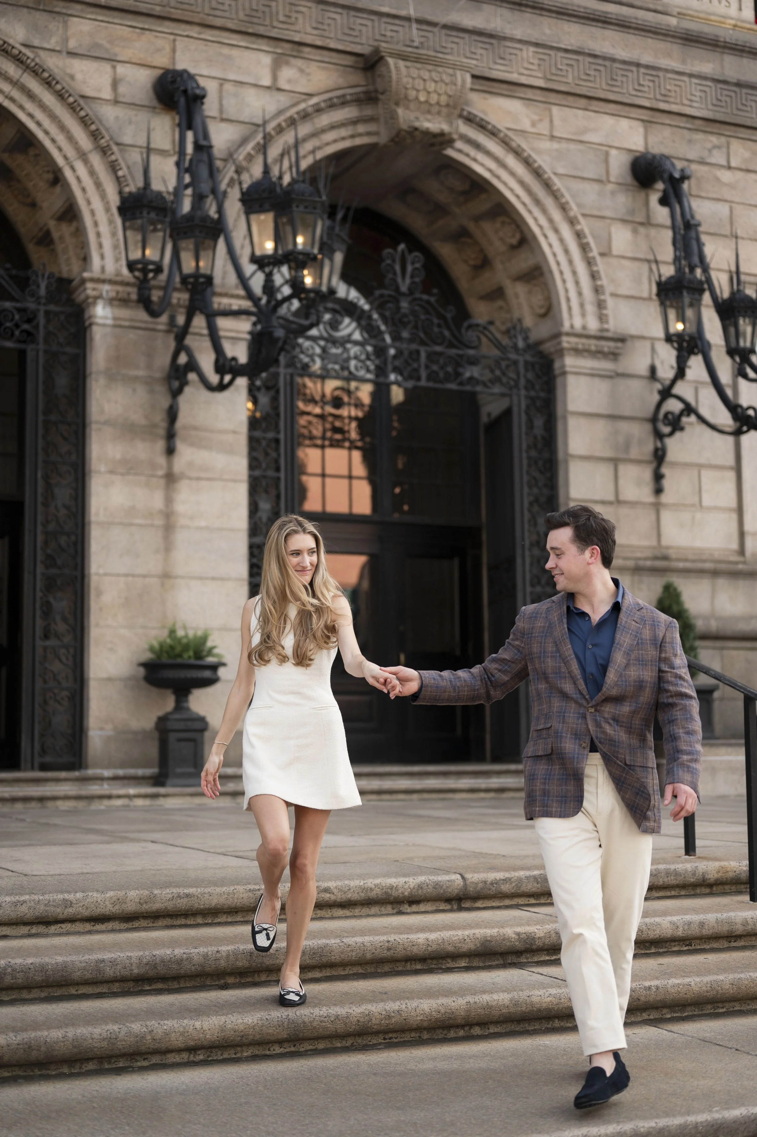 Cathryn and Brendan waling down the steps of the Boston Public Library during their engagement session