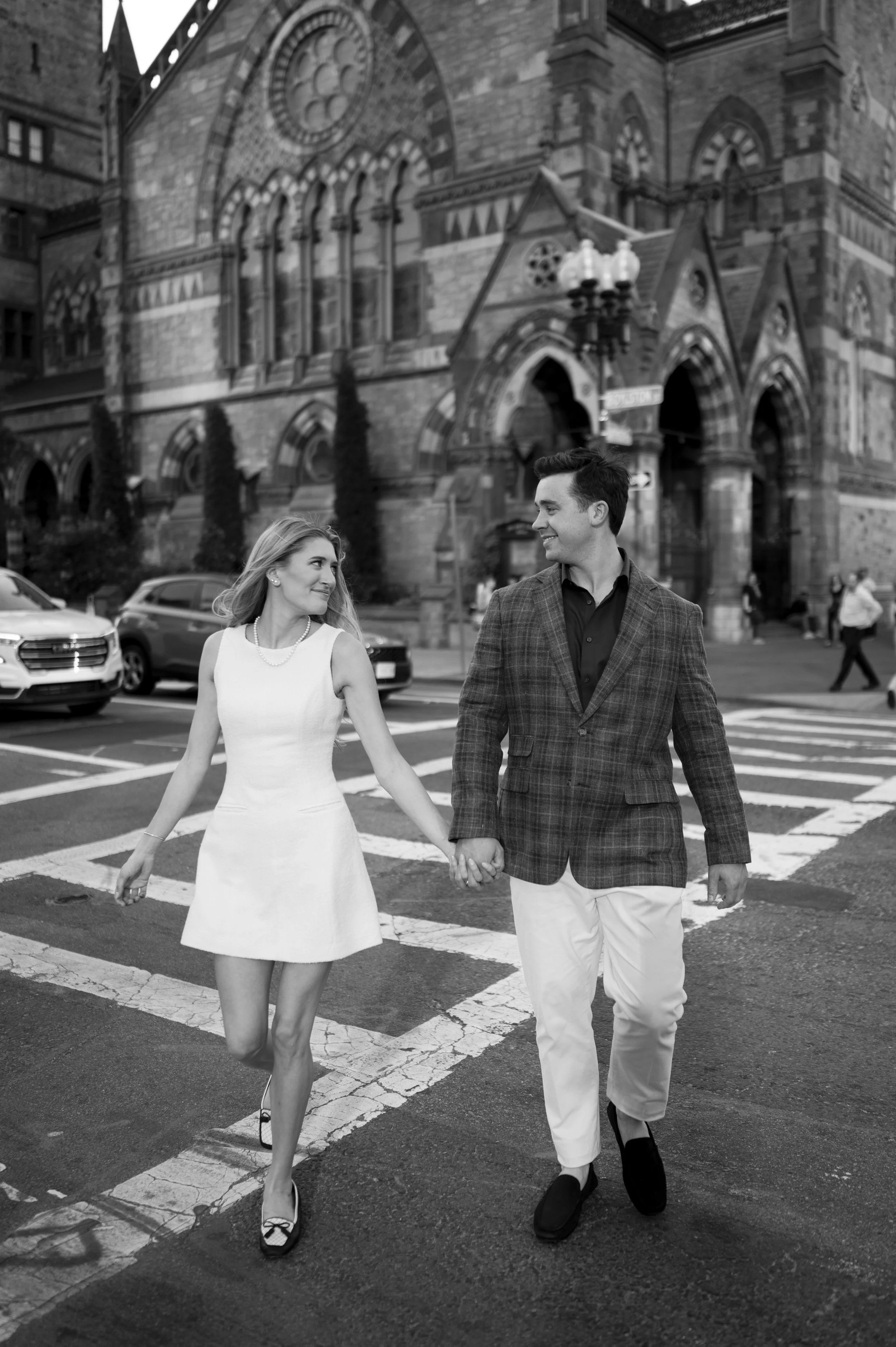 Cathryn and Brendan walking in front of copley plaza during their engagement session