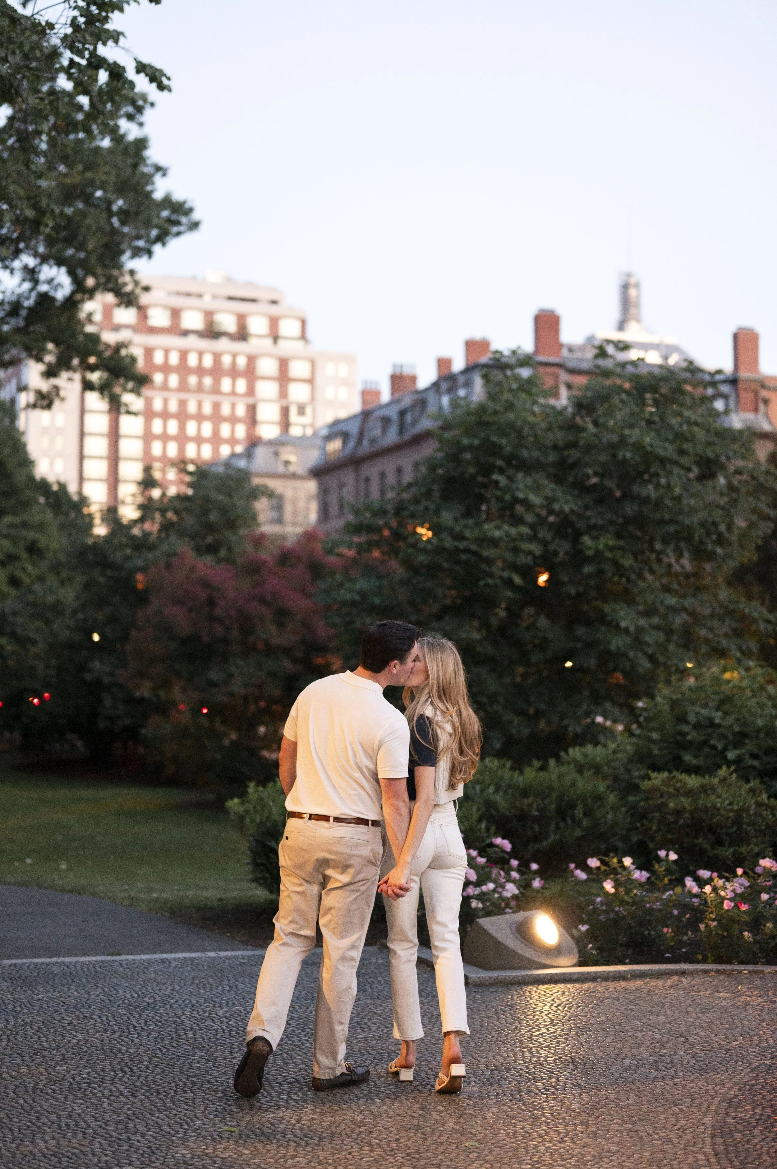 Cathryn and Brendan walking away during their sunset engagement session at boston public garden