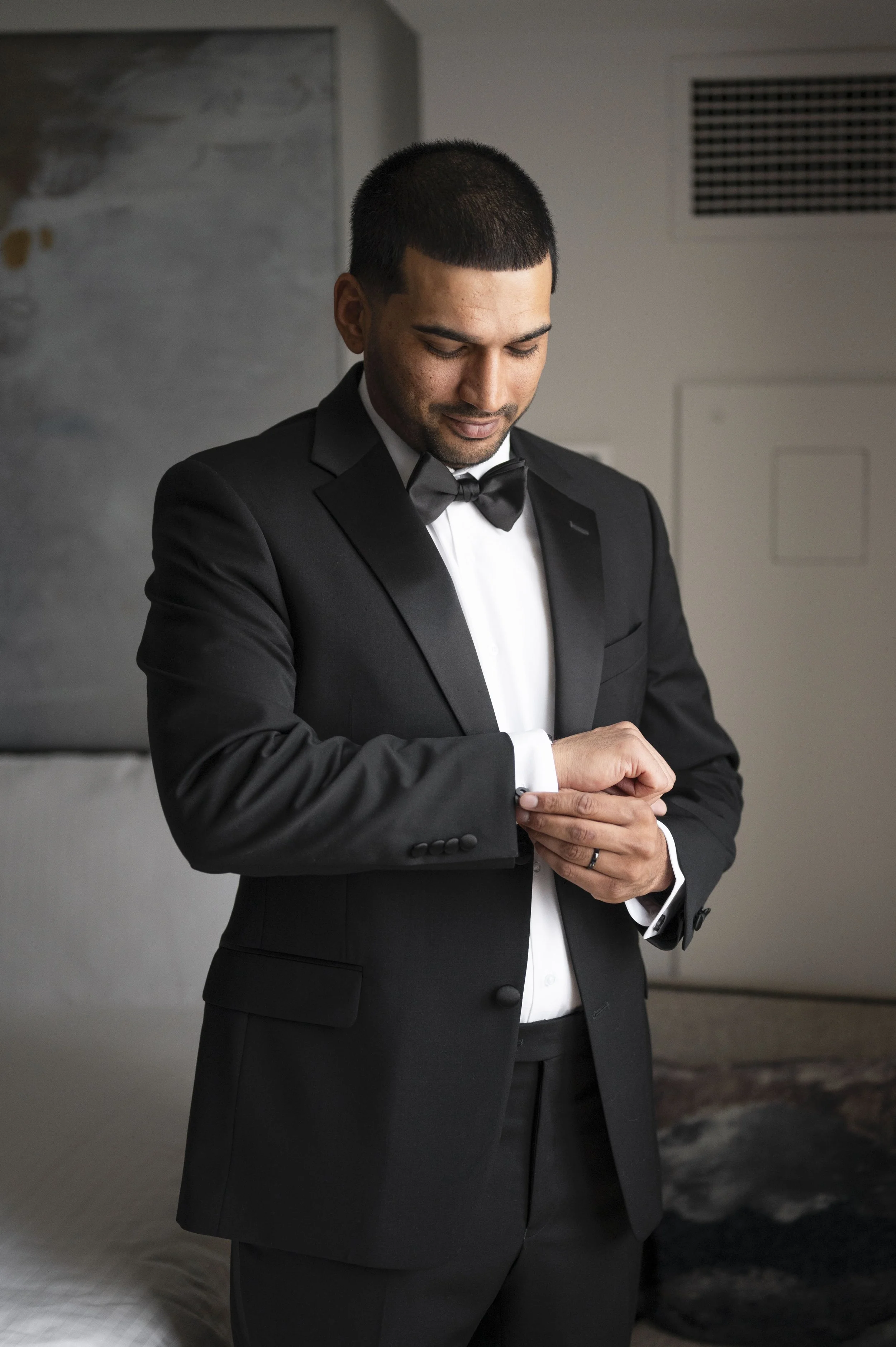 groom fixing his cuffs at the bridal suite at Loews hotel in Miami beach
