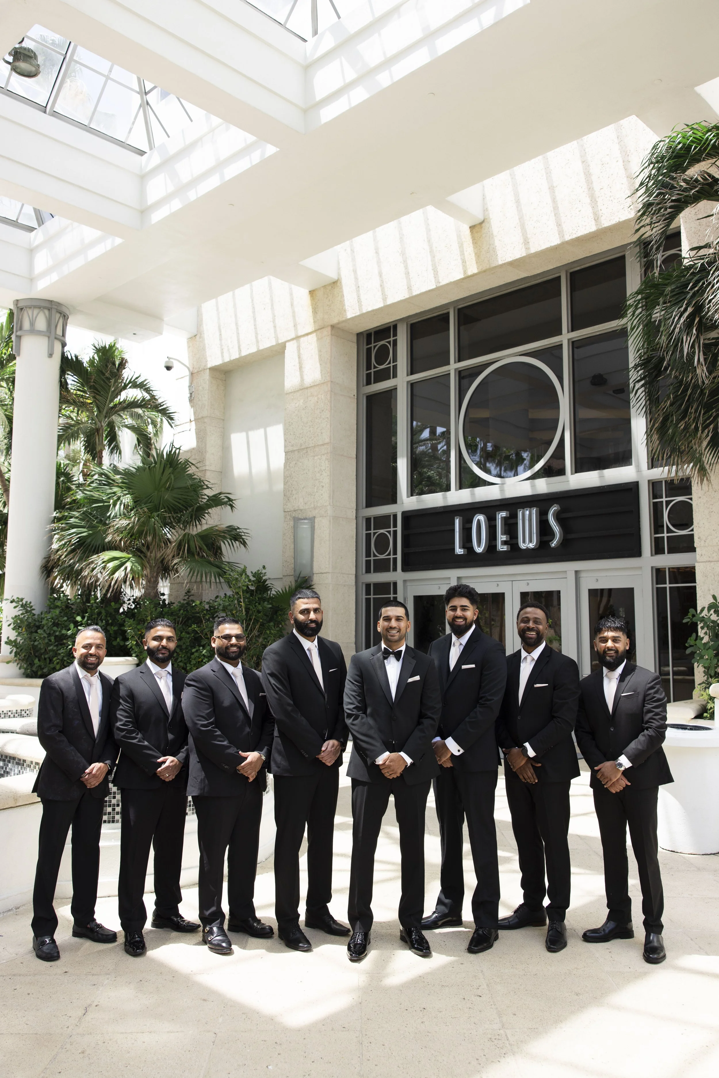 groom and groomsmen standing in front of the Loews hotel miami beach