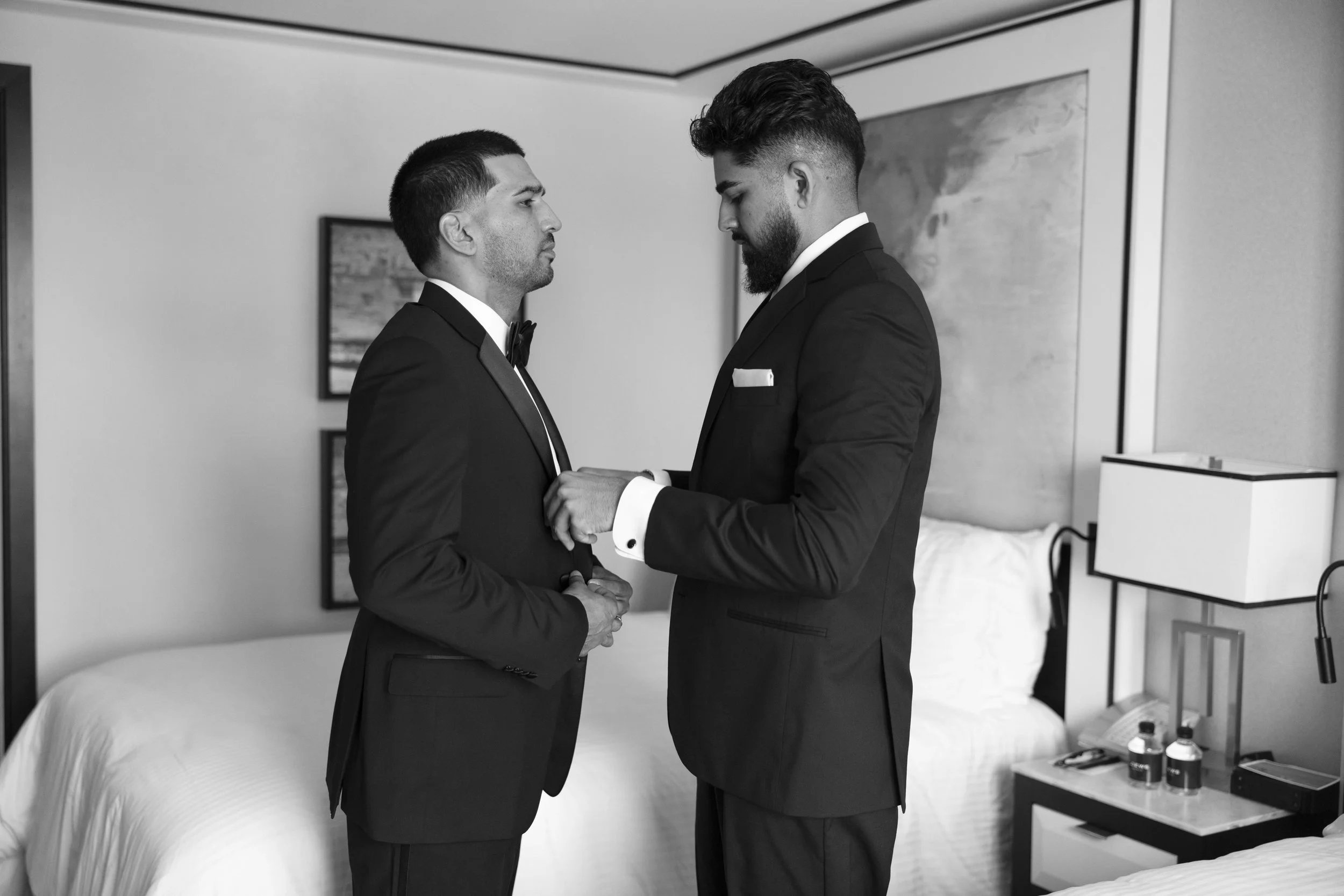 groom is being help to put on his jacket by his brother at the suite in the Loews hotel miami beach