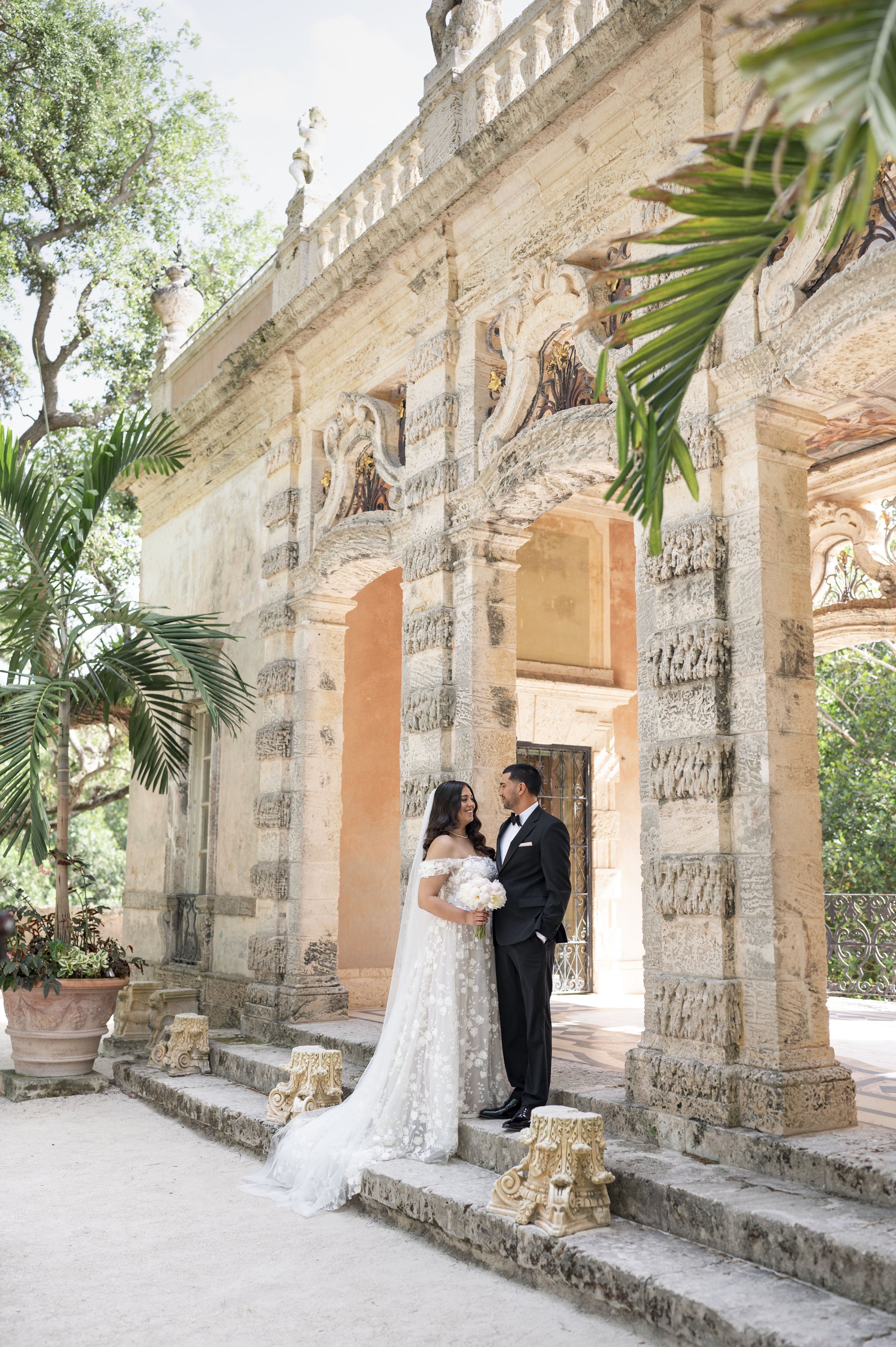 Bride and groom posing at the Vizcaya museum and gardens in their wedding day