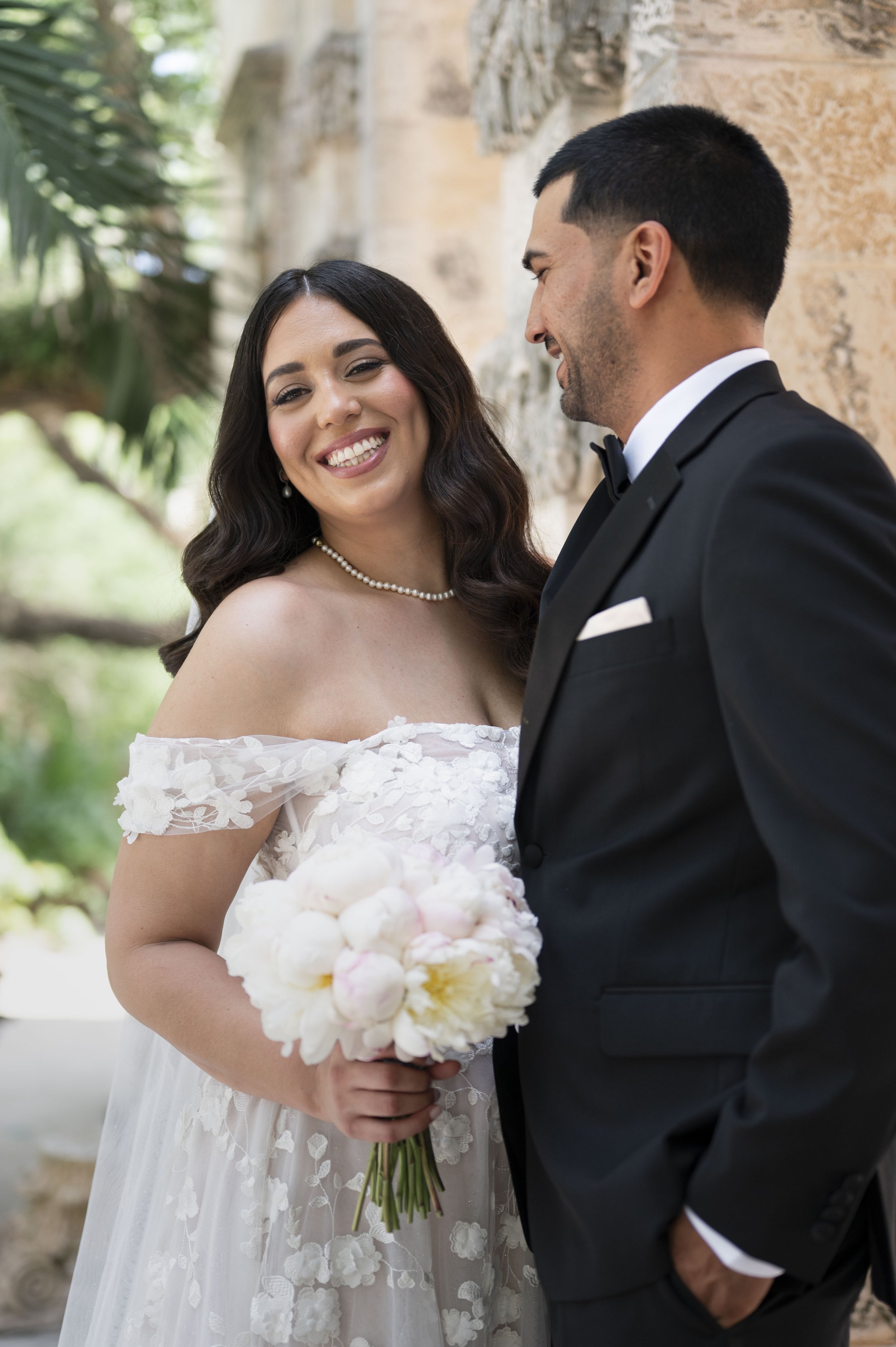 Bride and groom laughing at the Vizcaya museum and gardens in their wedding day
