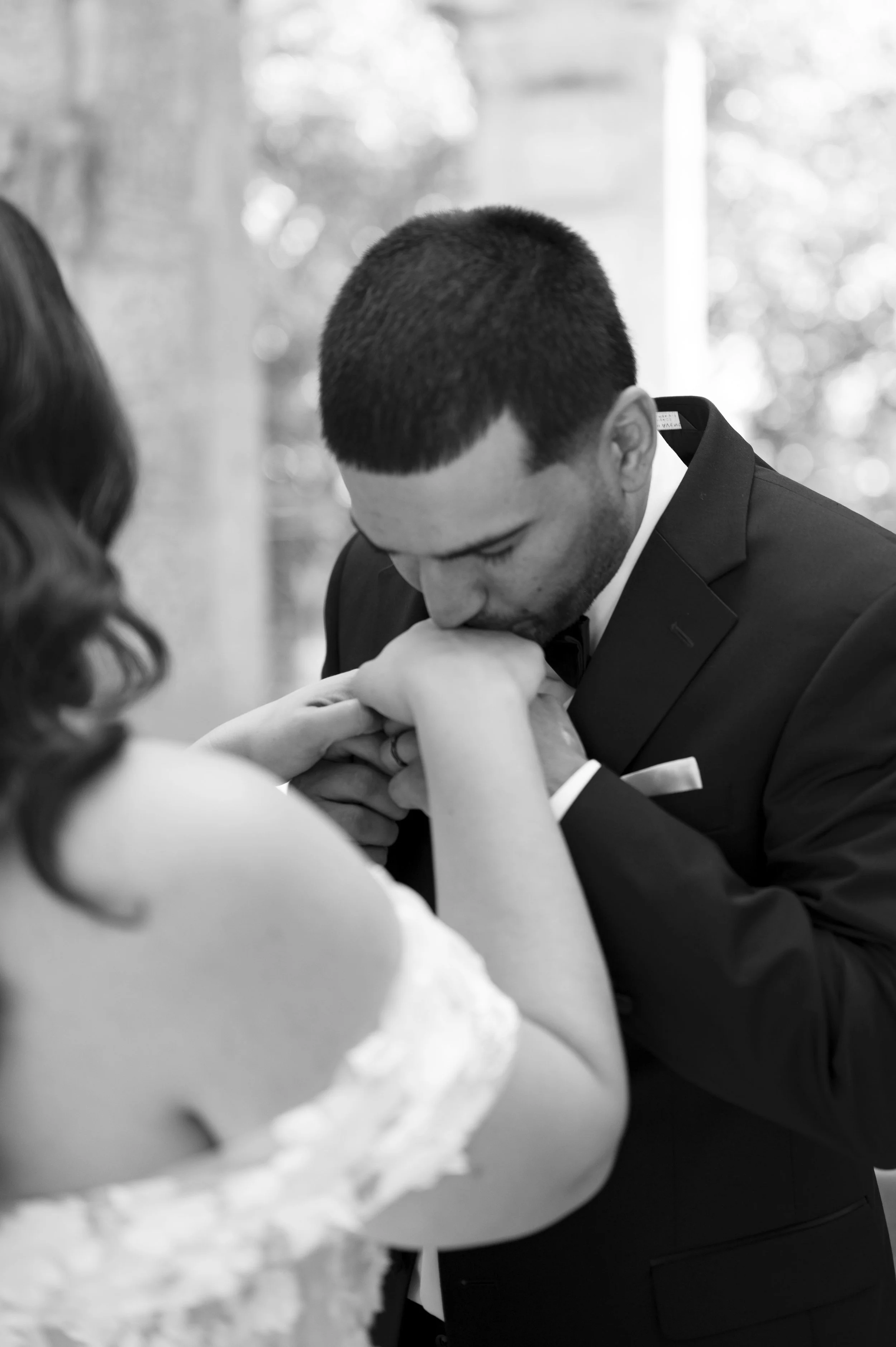 groom kissing bride's hand right after their first look at the vizcaya museum on their wedding day