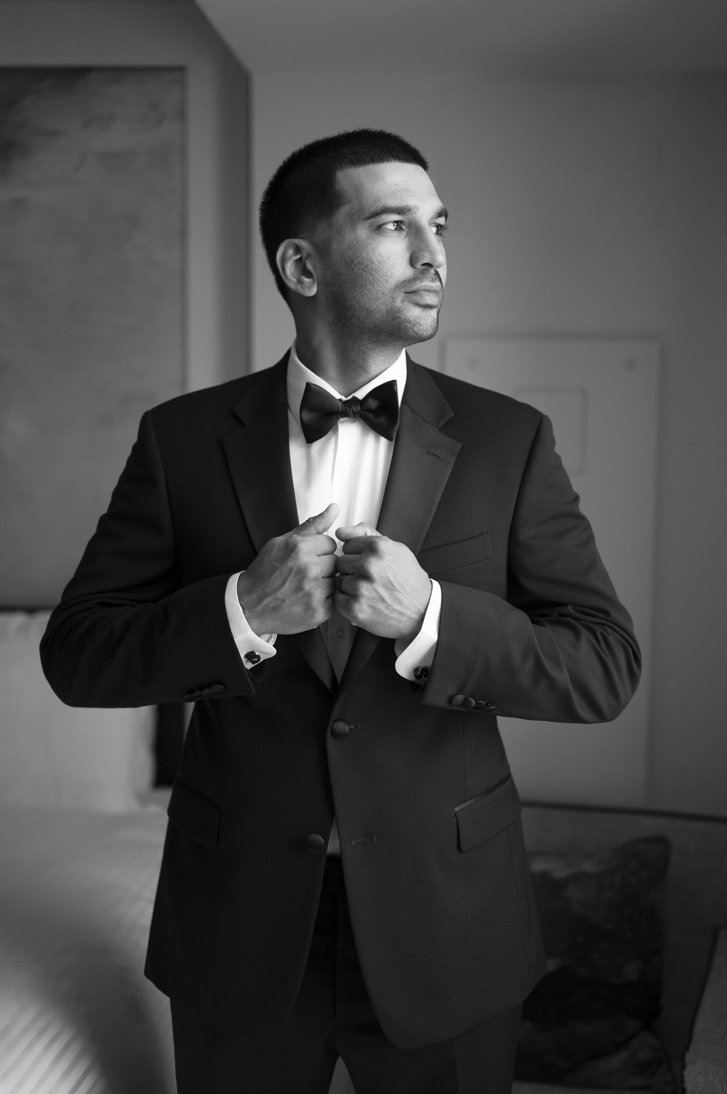 groom holding his tux jacket as he gets ready for his wedding at the Vizcaya museum