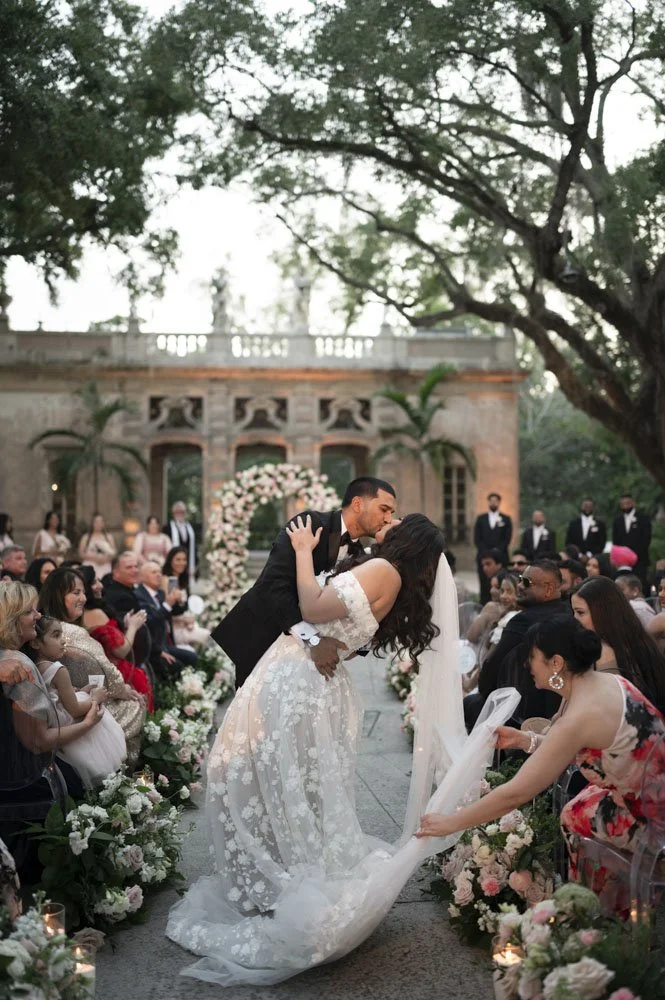 groom kissing bride in the middle of the isle exiting their ceremony at the vizcaya museum and gardens in miami
