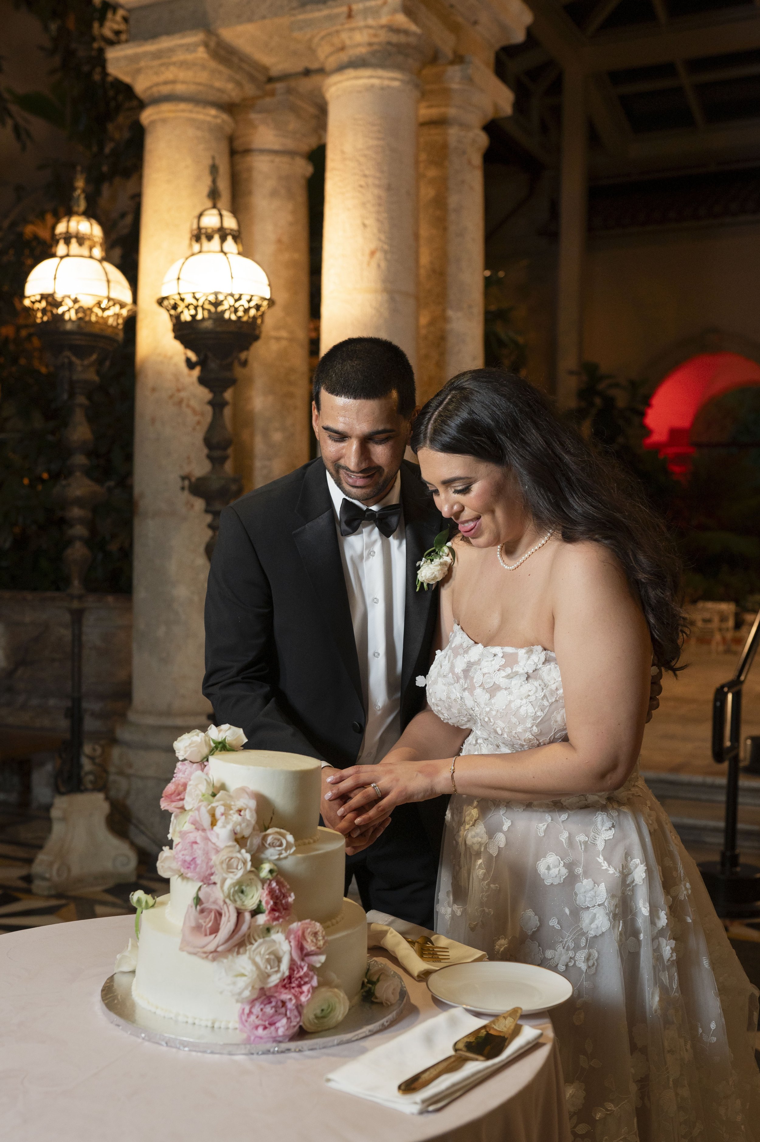 bride and groom cutting their wedding cake at the vizacaya museum and gradens