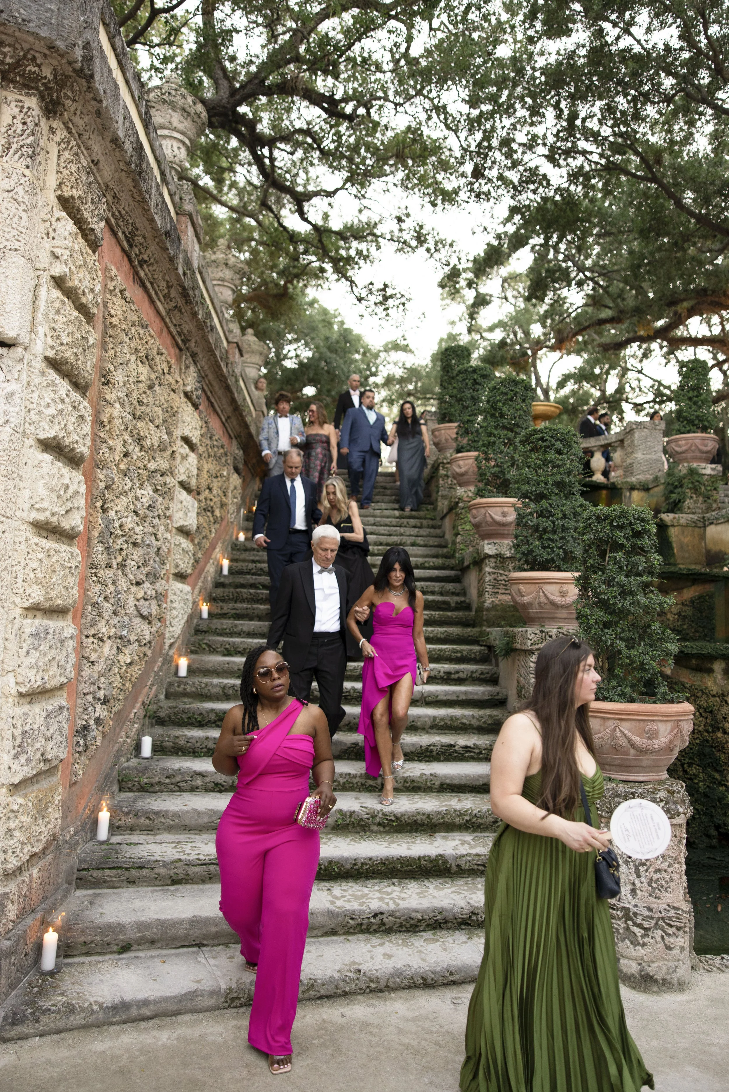 luxury wedding guests walking down the stairs from ceremony at the vizcaya museum and gardens in miami