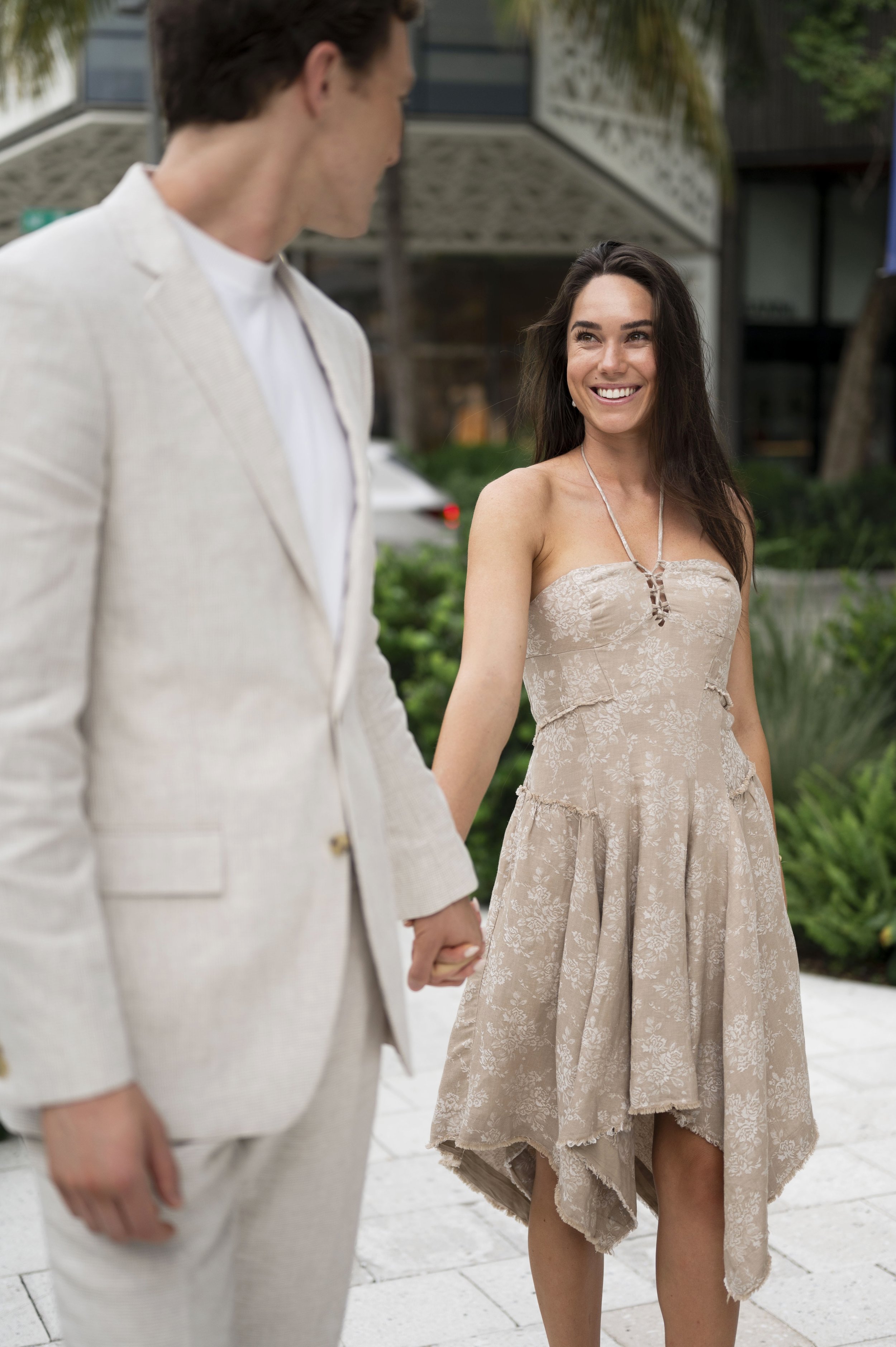 Rachel looks at Travis while holding hands during their engagement session at the design district in miami