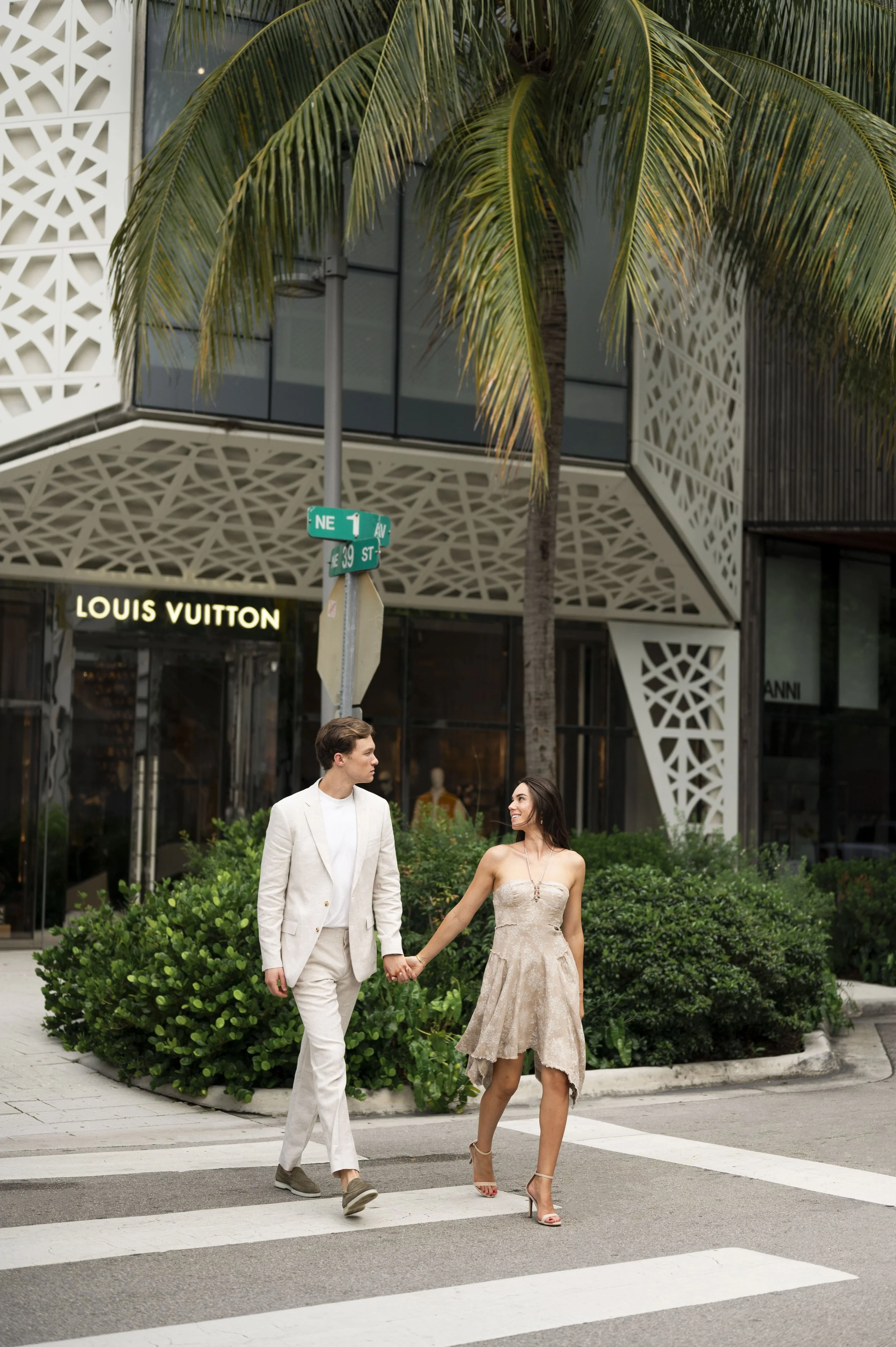 Travis and Rachel walking through the streets of miami design district during their engagement session