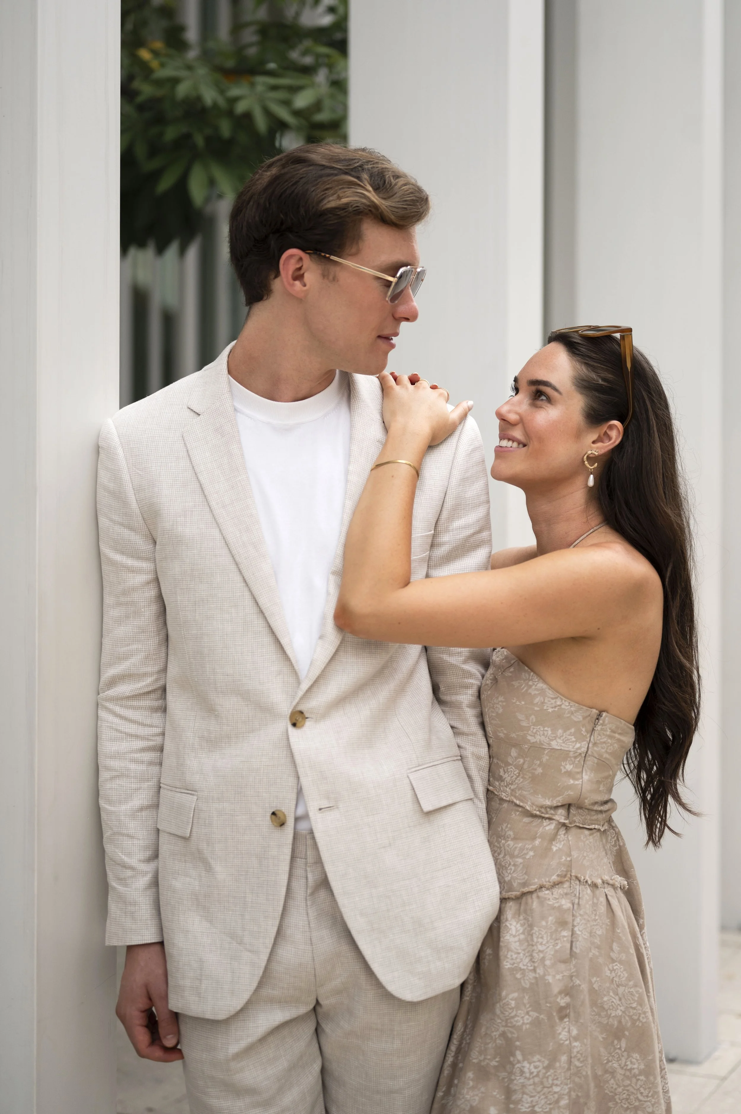 Rachel and Travis looking at each other in Miami design district during their engagement session