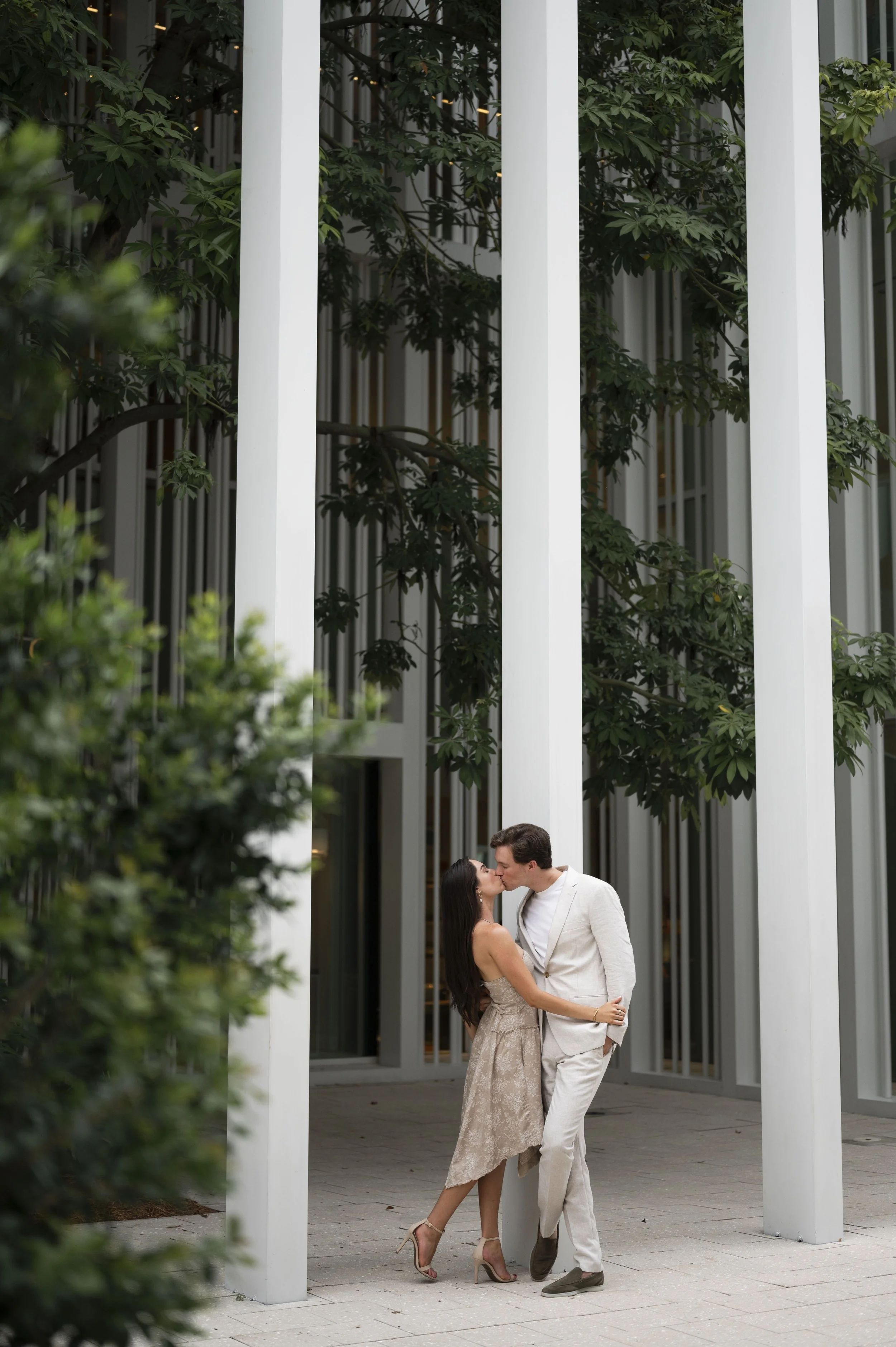 Travis and Rachel kissing in front of the Hermes store in the design district during their engagement session