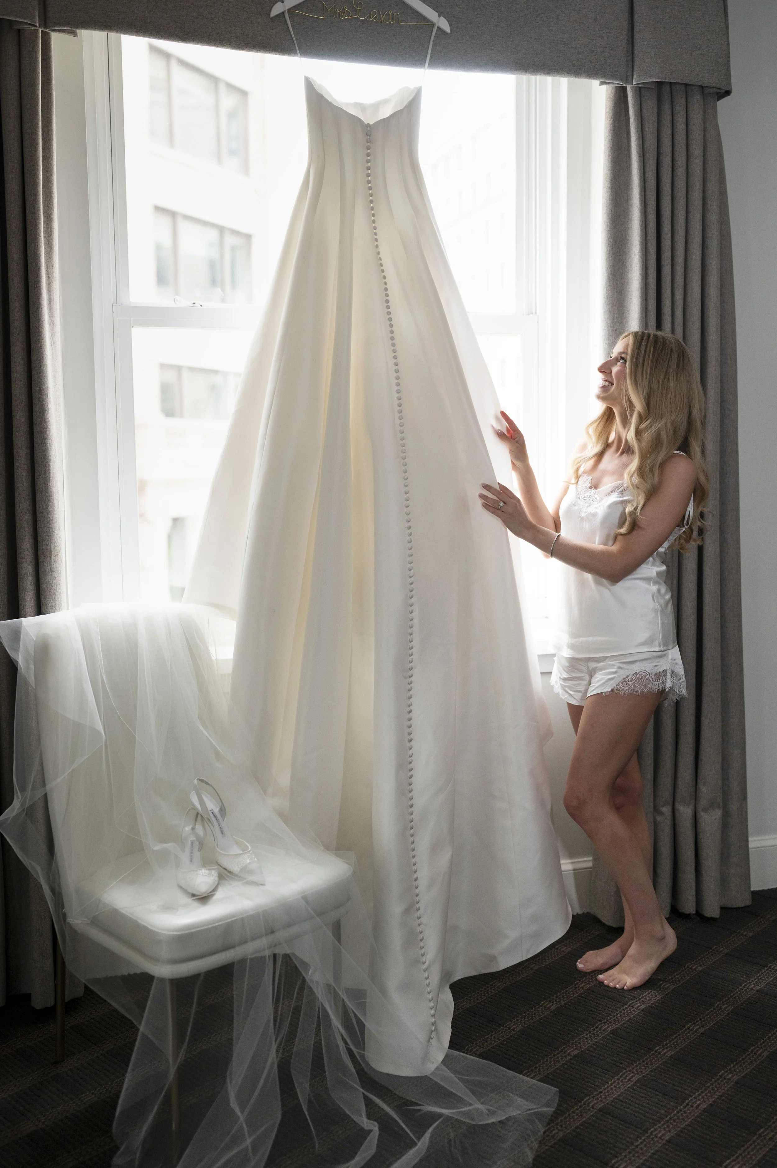 bride looking at her dress wearing pijamas
